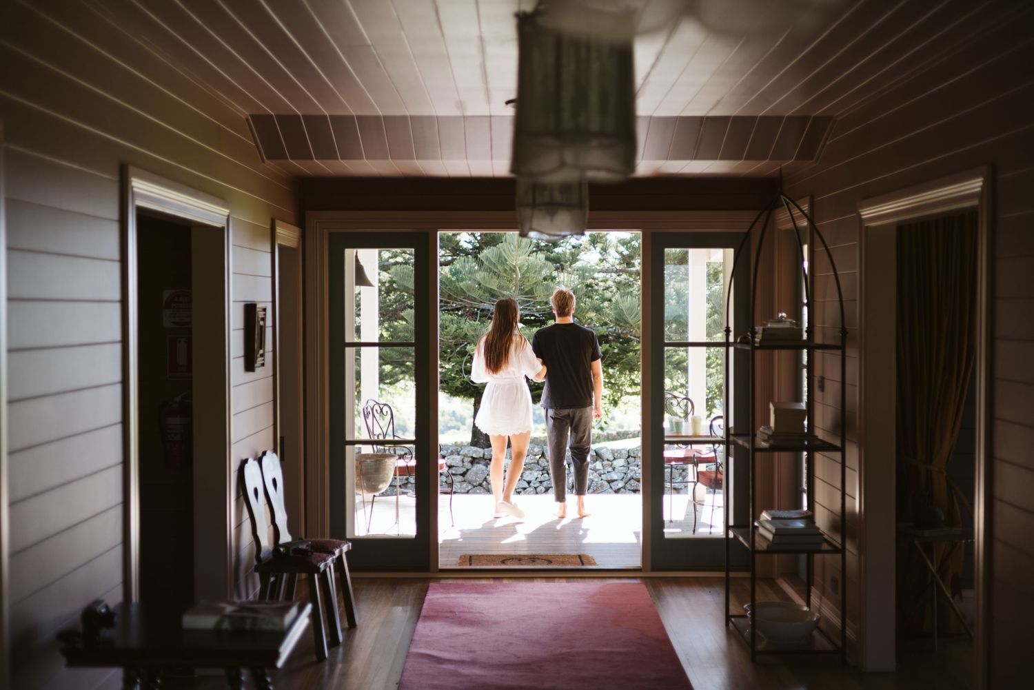 Wooden entrance hall with glass doors opening to an outdoor patio.