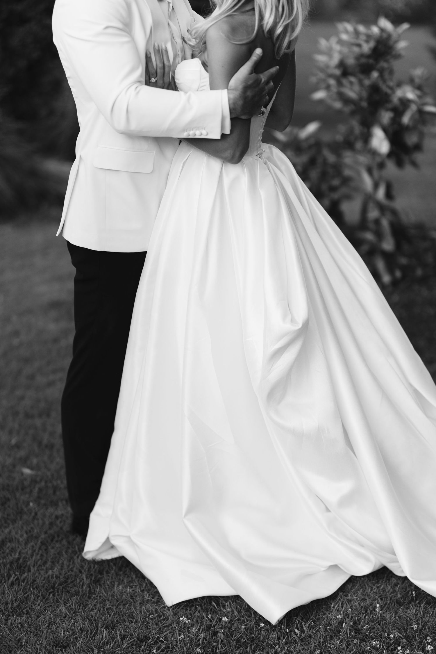Black and white portrait capturing romantic dance between bride and groom.
