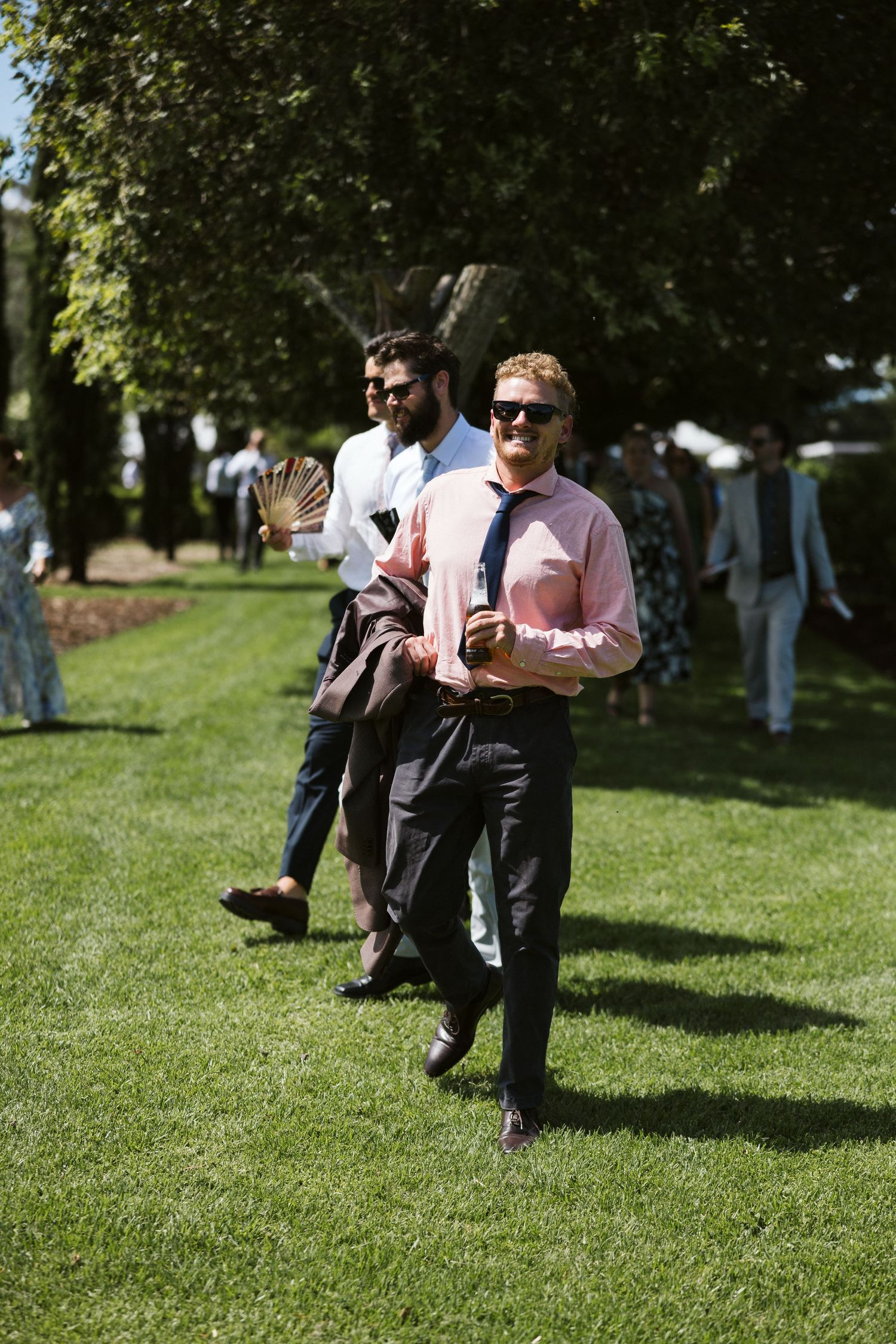 Party guests enjoying themselves on a sunny lawn at an outdoor event.