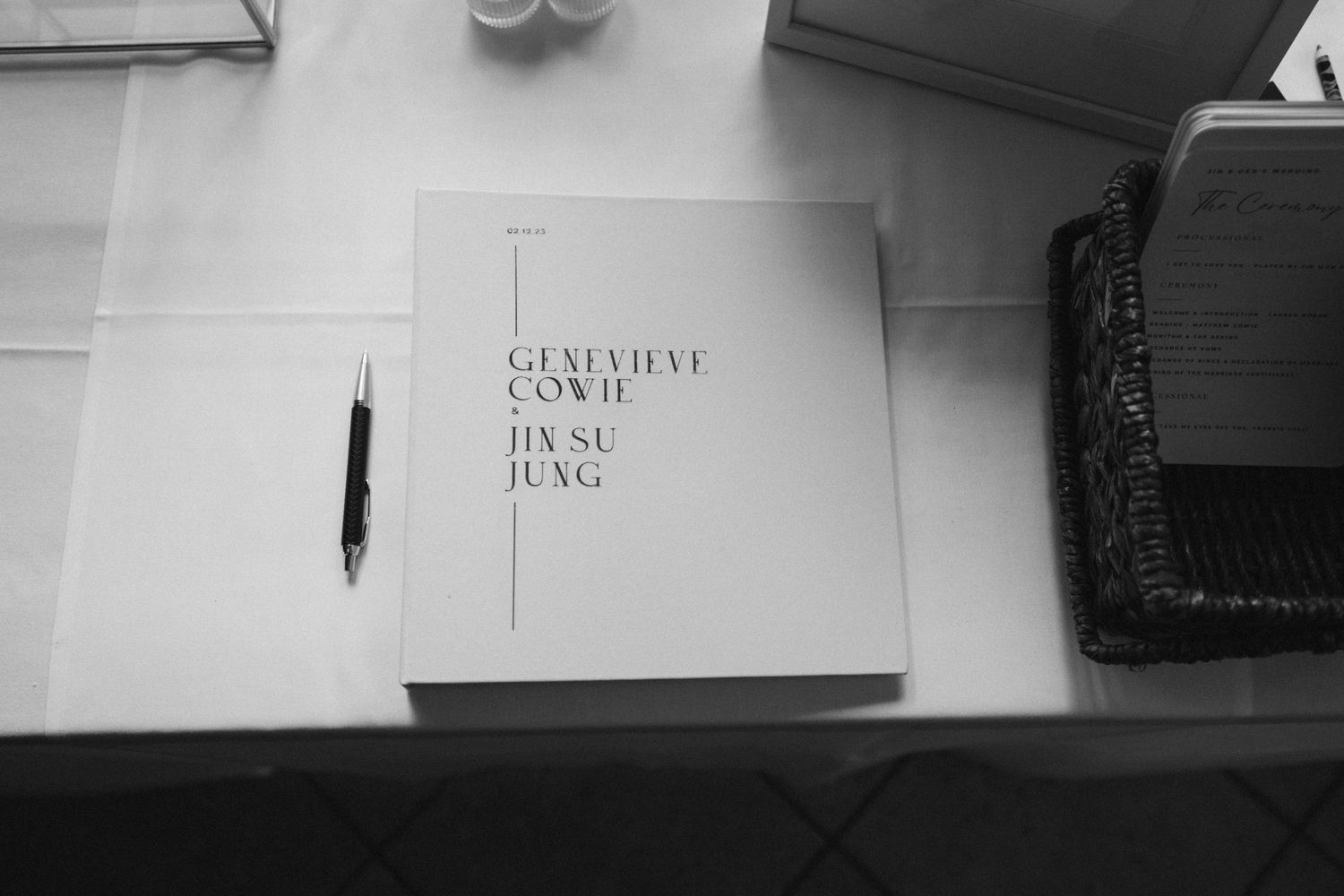 A black and white photo of a wedding guest book on a table.