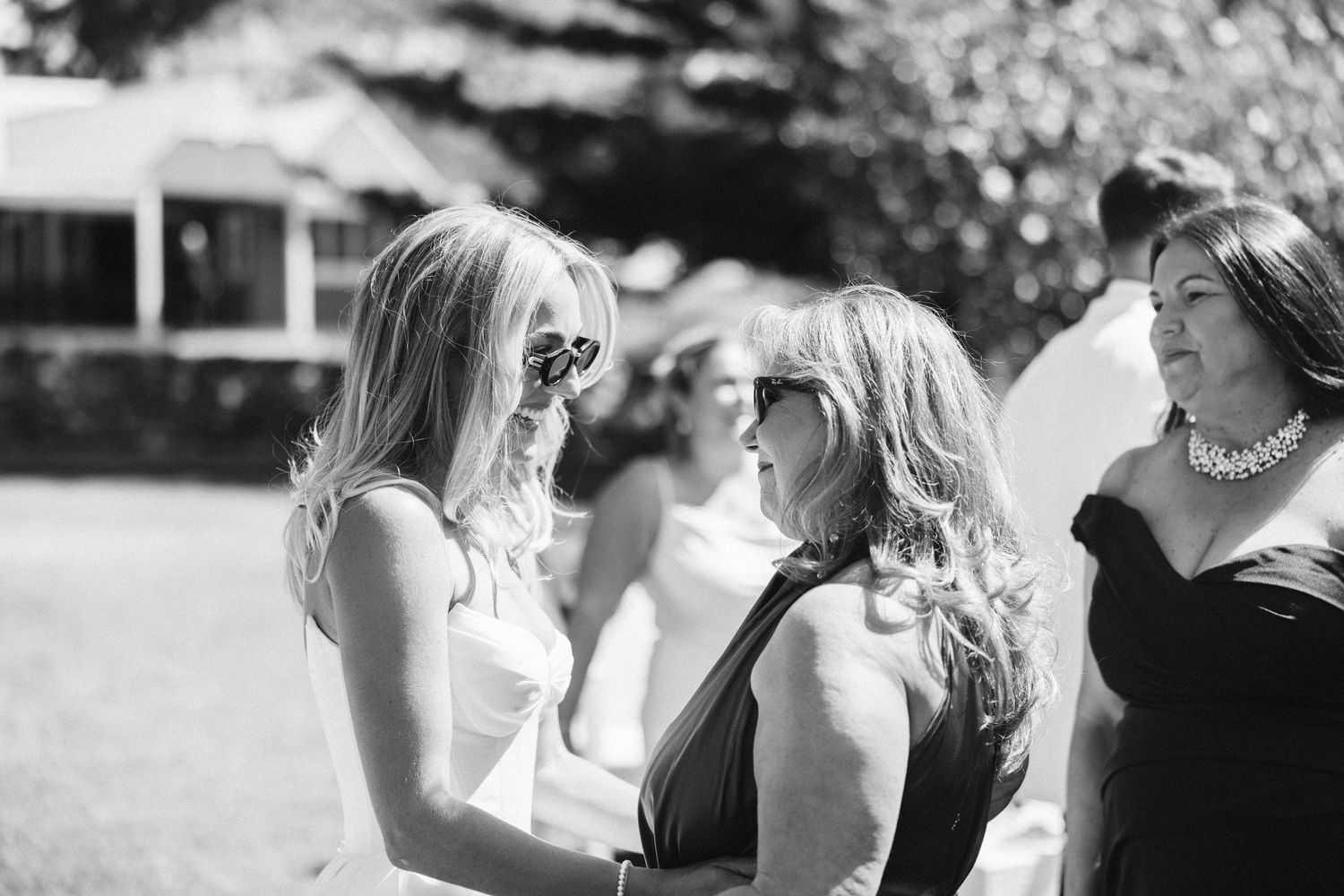 A tender black and white moment between guests at an outdoor wedding celebration.