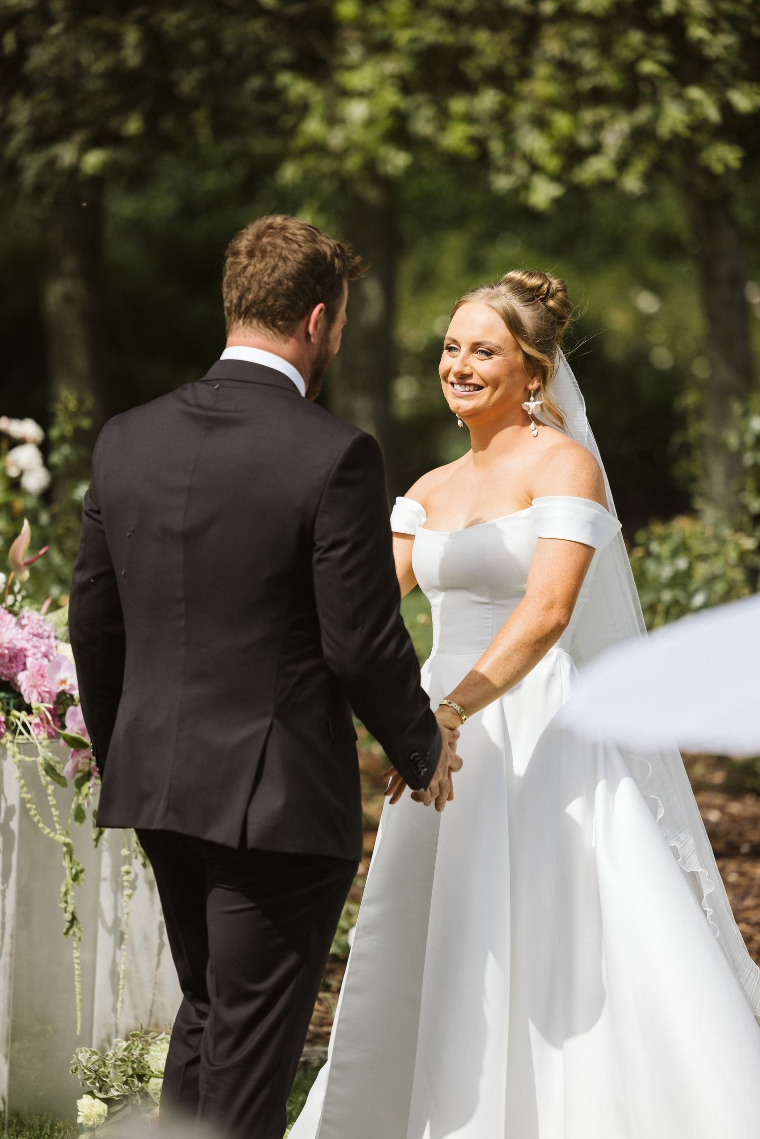 Elegant outdoor wedding ceremony with couple sharing joyful moment.