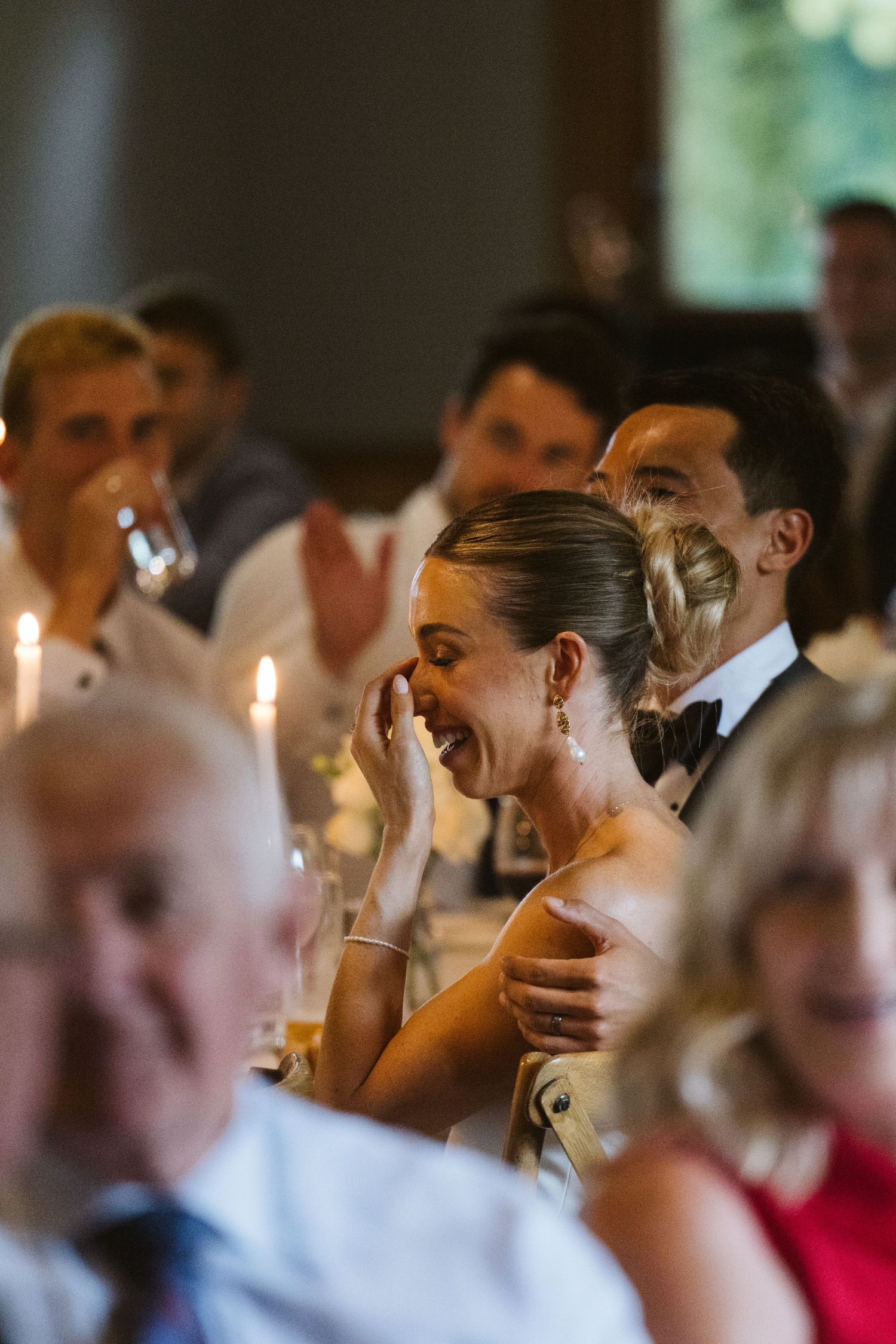 Emotional wedding guest reacts during ceremony while others look on.