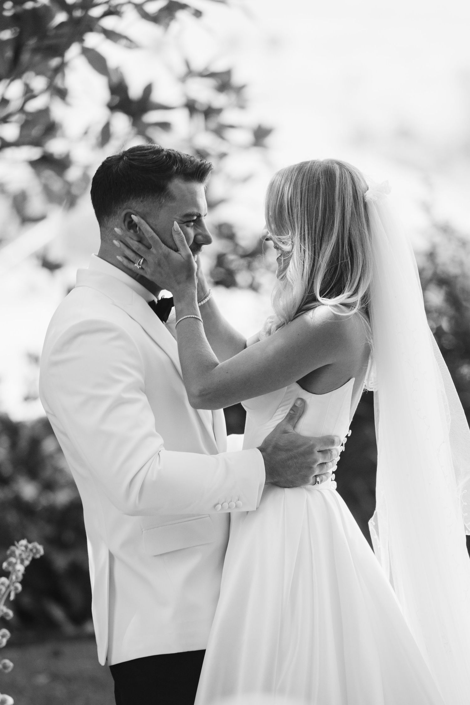 Black and white emotional moment captured between couple during wedding ceremony.