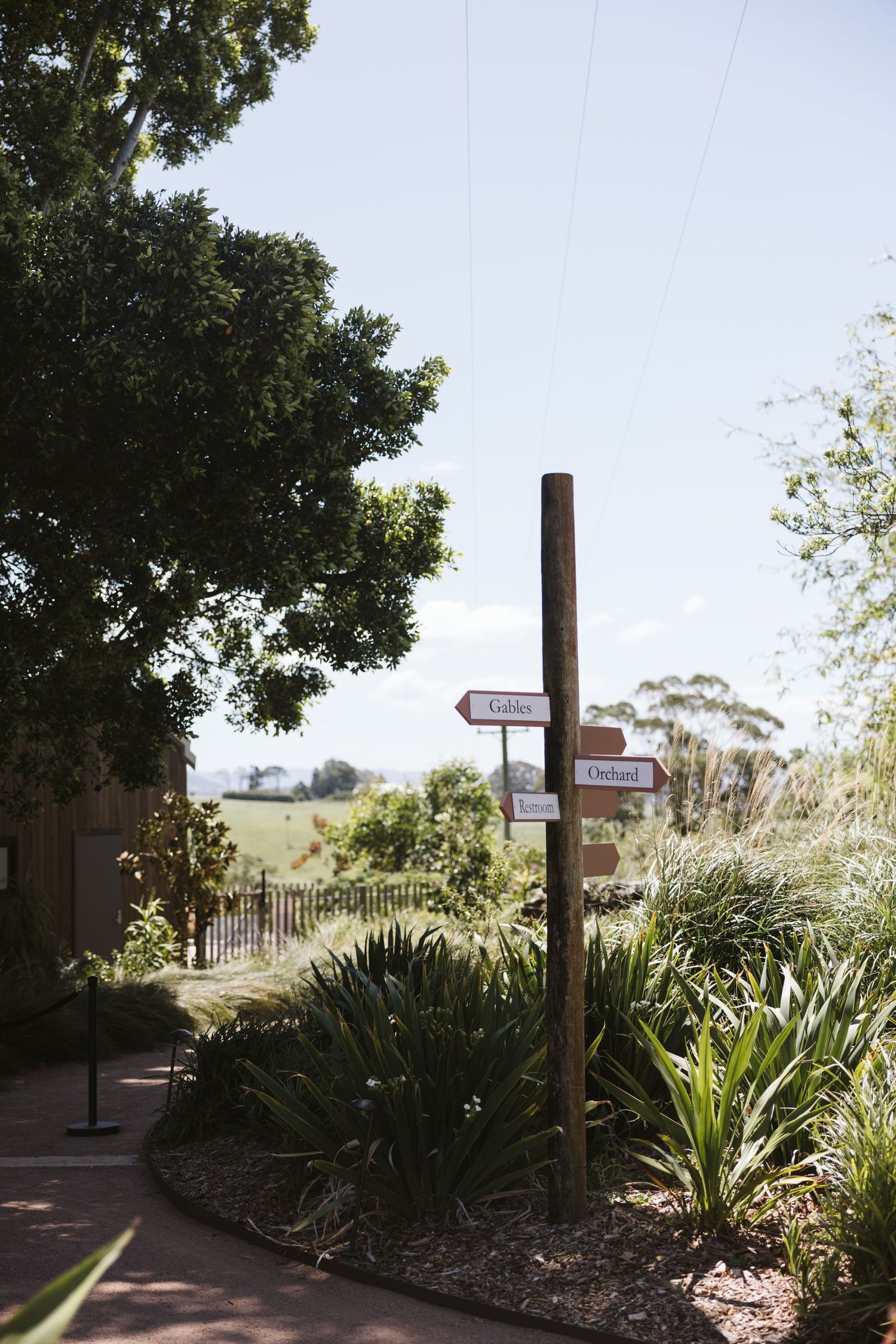 Wooden directional signs mark various garden paths amidst lush landscaping.
