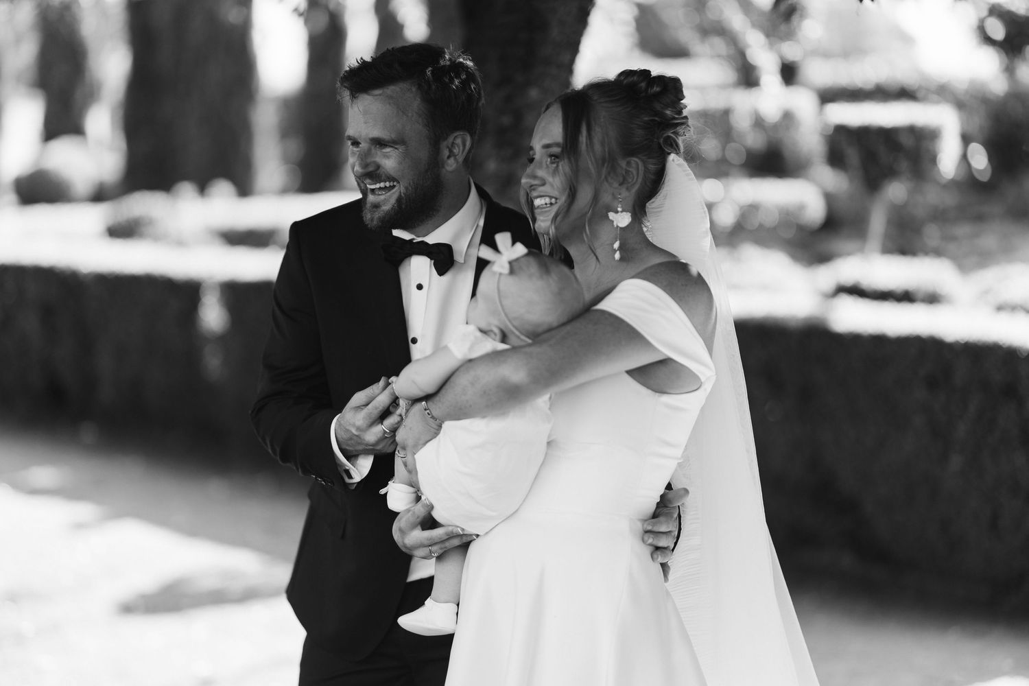 Black and white wedding photo capturing intimate moment outdoors.