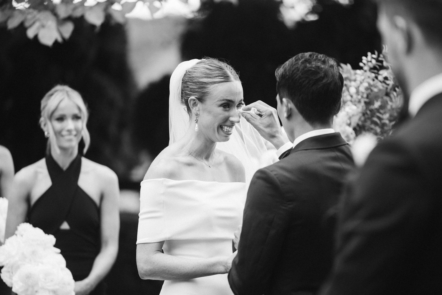 Intimate wedding ceremony moment outdoors with floral decorations.