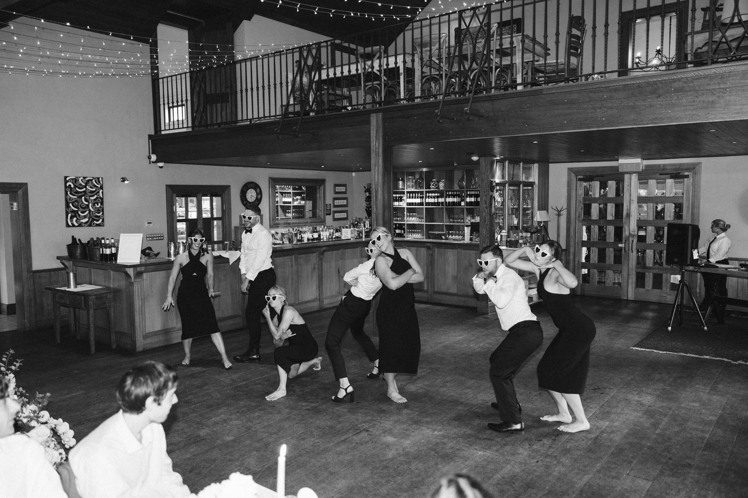 Vintage style black and white photo of guests swing dancing at wedding reception.