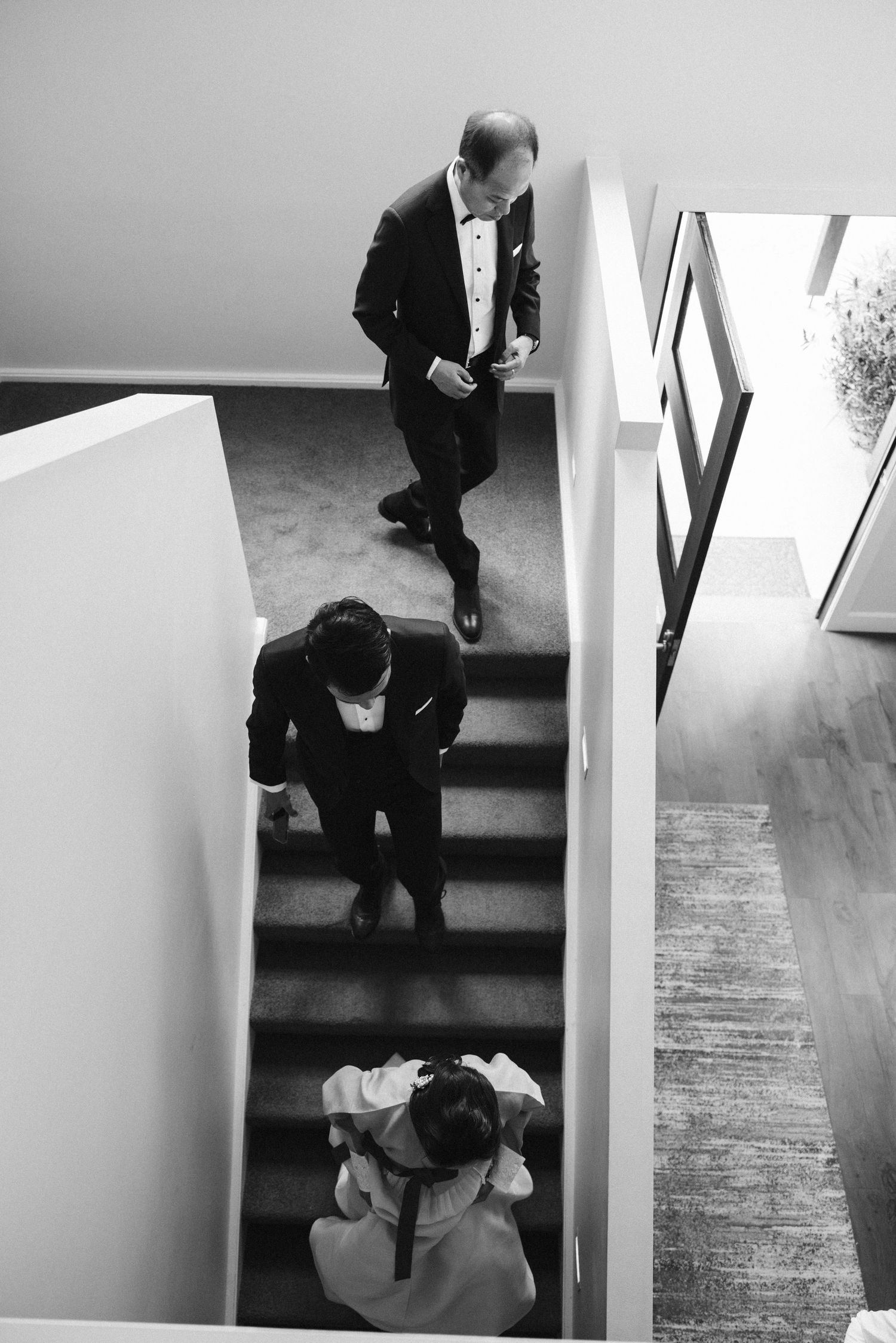 An overhead view of wedding party members descending a staircase.
