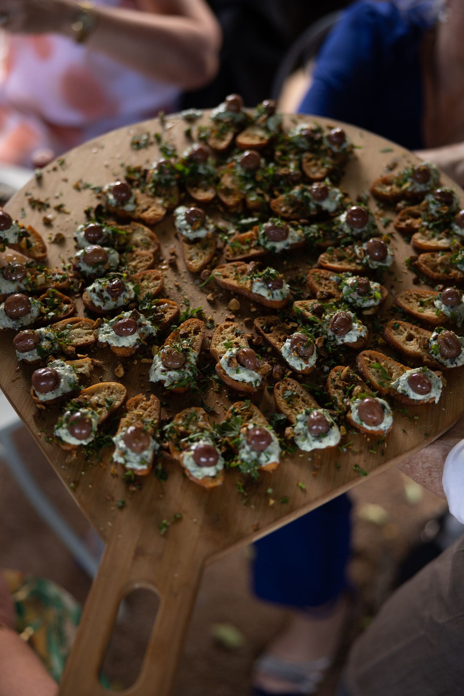 Gourmet appetizers arranged on wooden serving board with fresh herbs and garnishes.