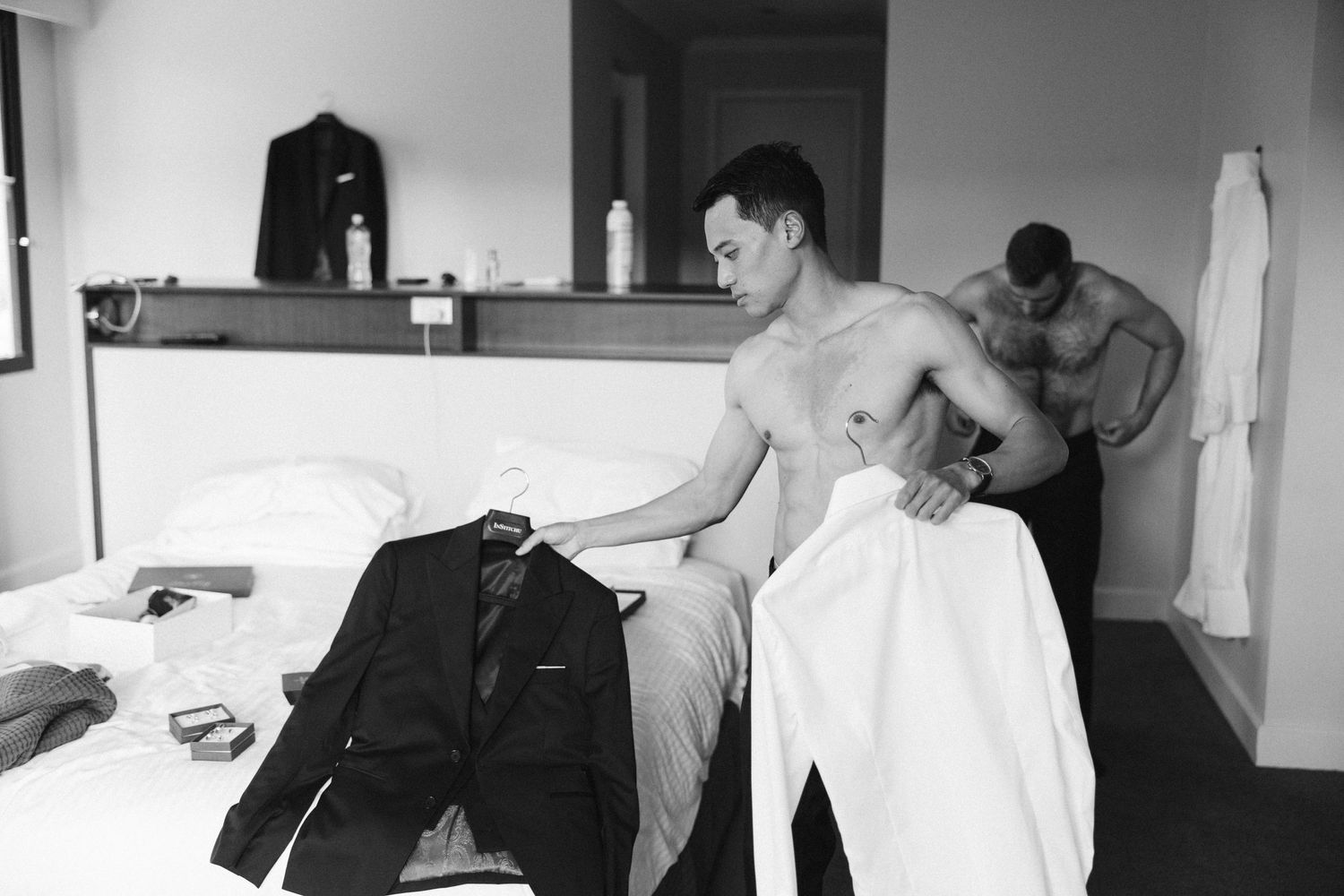 Wedding preparations in a hotel room as formal attire is laid out on the bed.