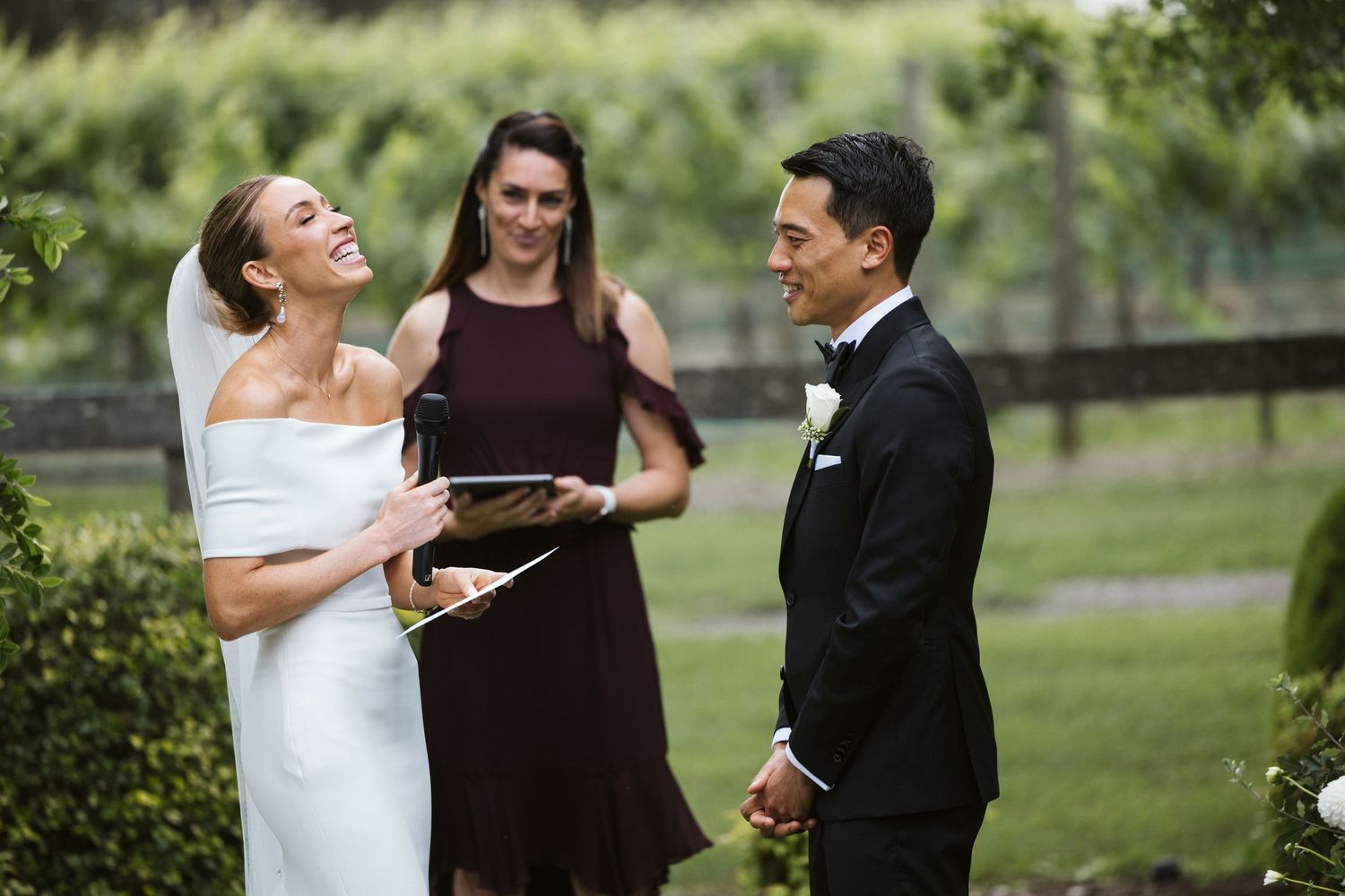 Joyful moment during outdoor wedding ceremony with officiant.
