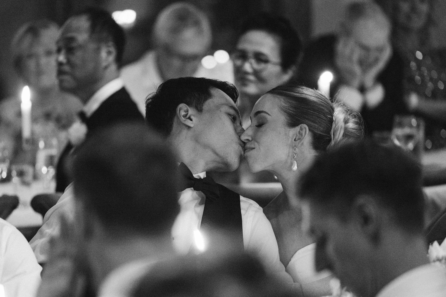 Intimate candlelit moment between newlyweds during wedding reception.