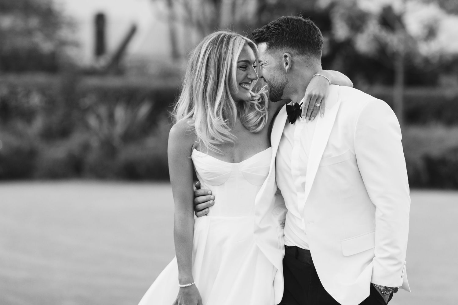 Black and white portrait of newlyweds sharing an intimate moment.