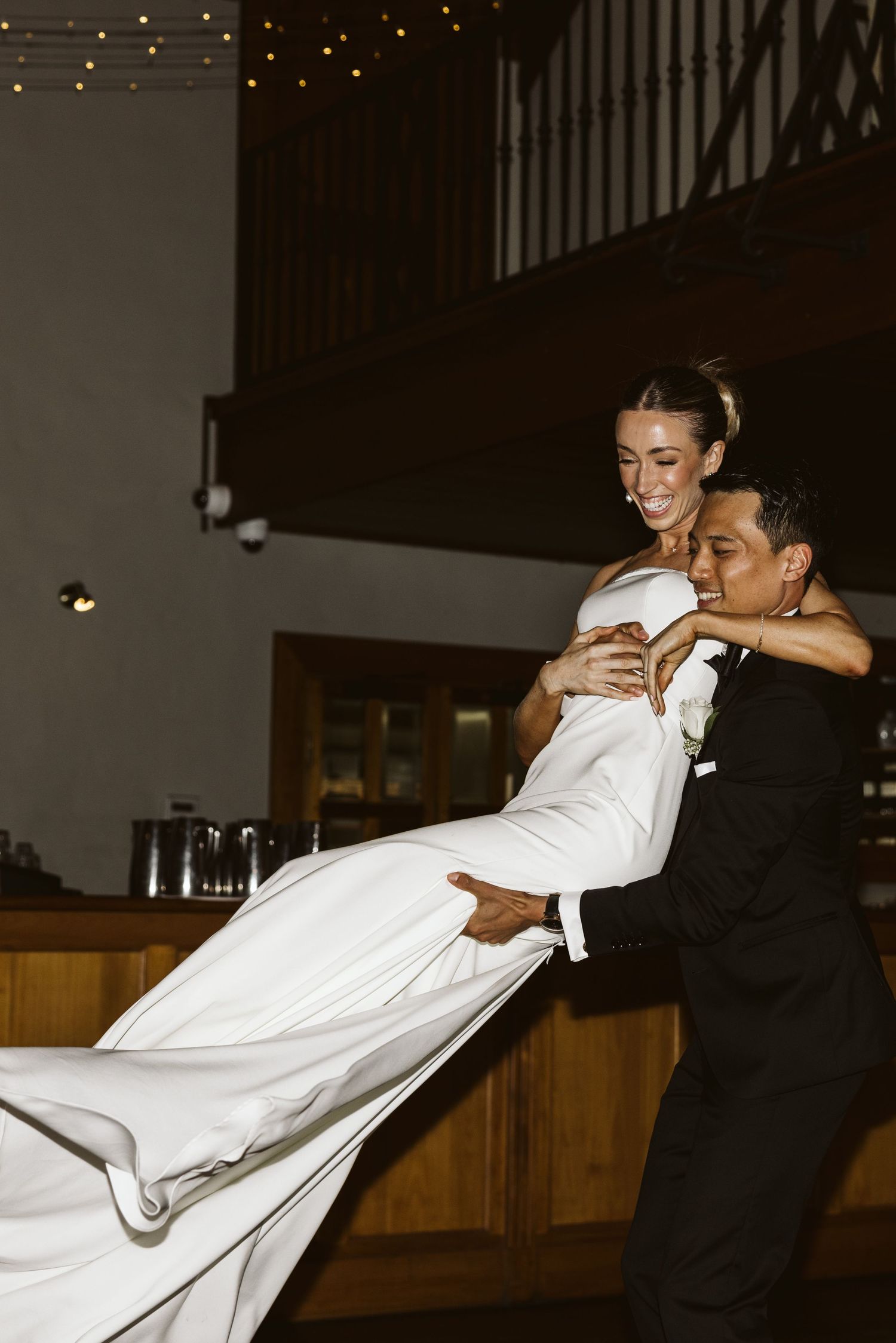 A couple performs an impressive dance lift showing off the bride's flowing white gown.