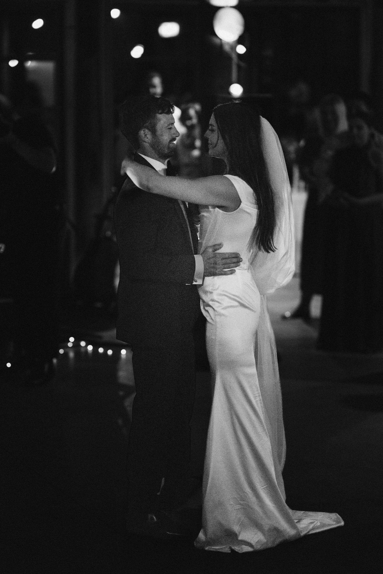 Romantic first dance in black and white with couple in formal wedding attire.
