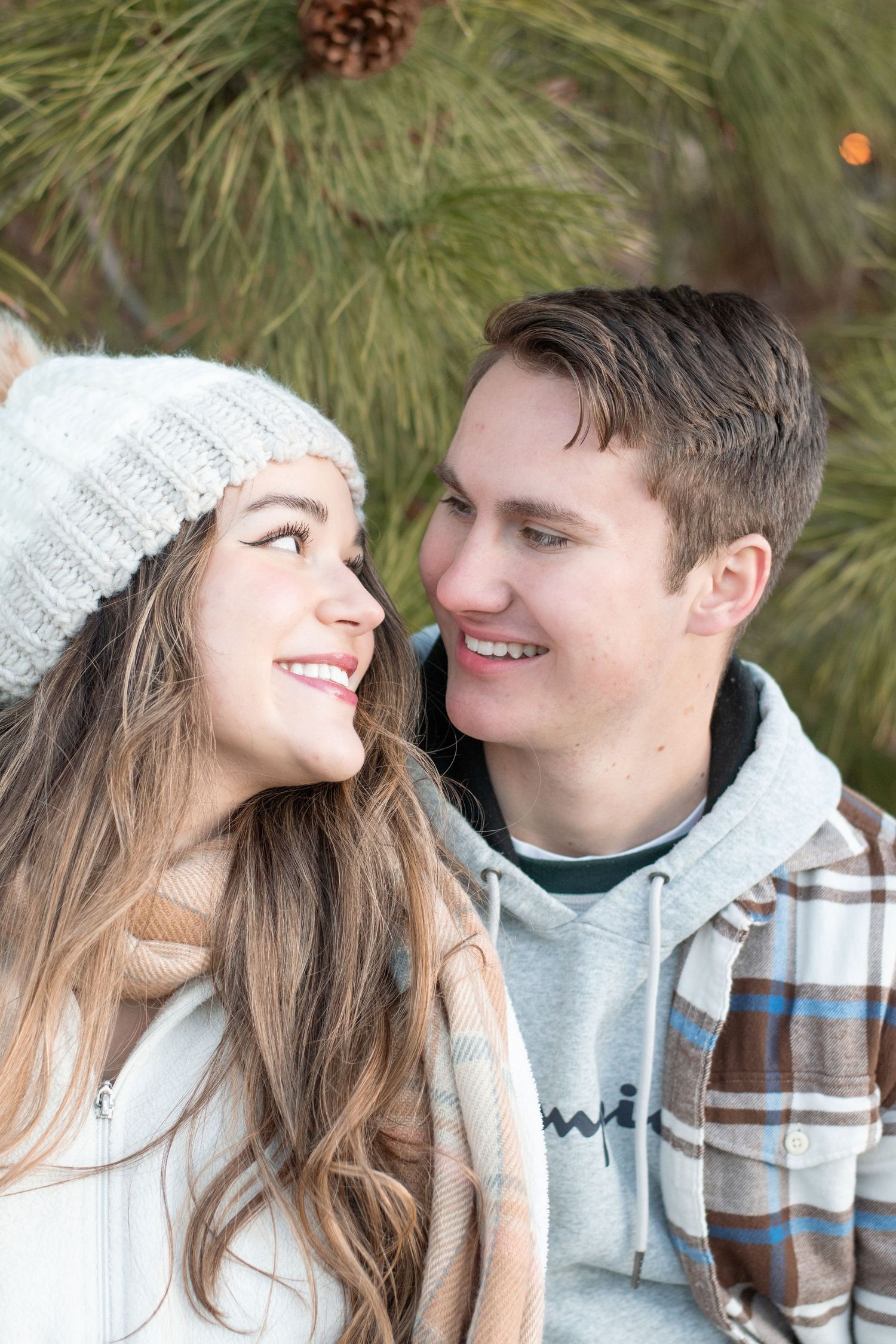 Intimate winter portrait session with cozy knit accessories and plaid scarves.