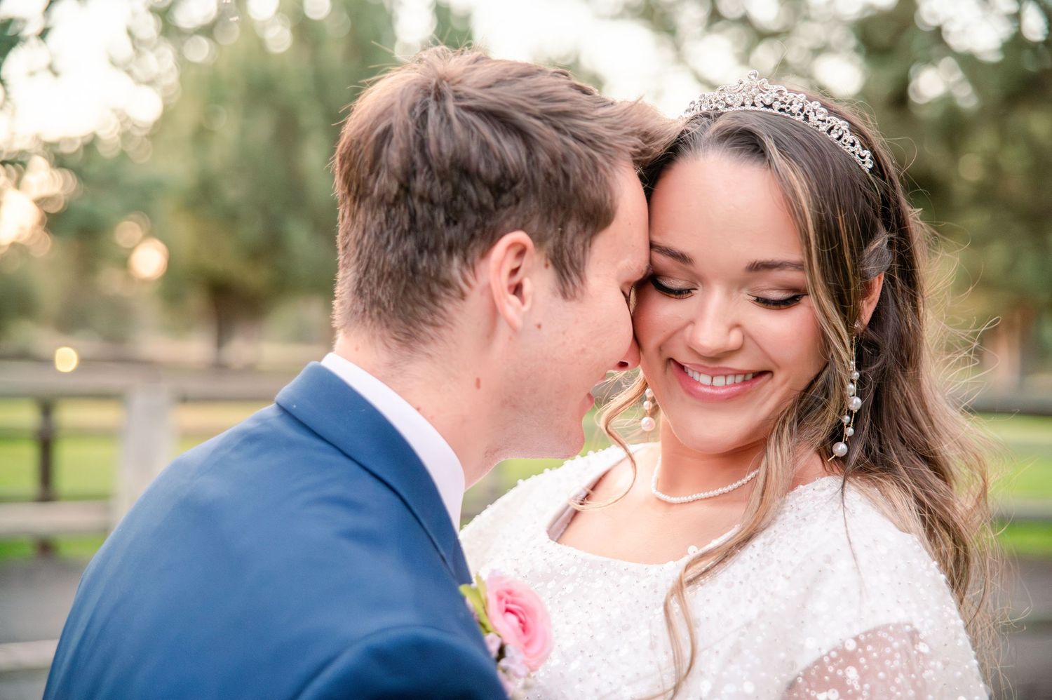 Romantic wedding couple embracing in garden with string lights.