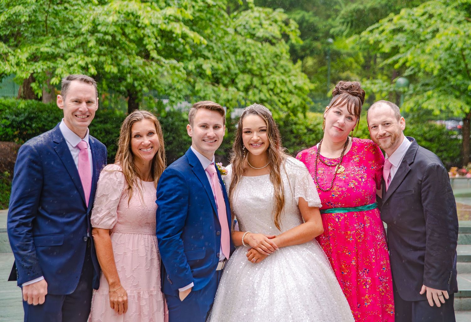 Outdoor wedding party portraits with coordinated pink and blue formal attire.