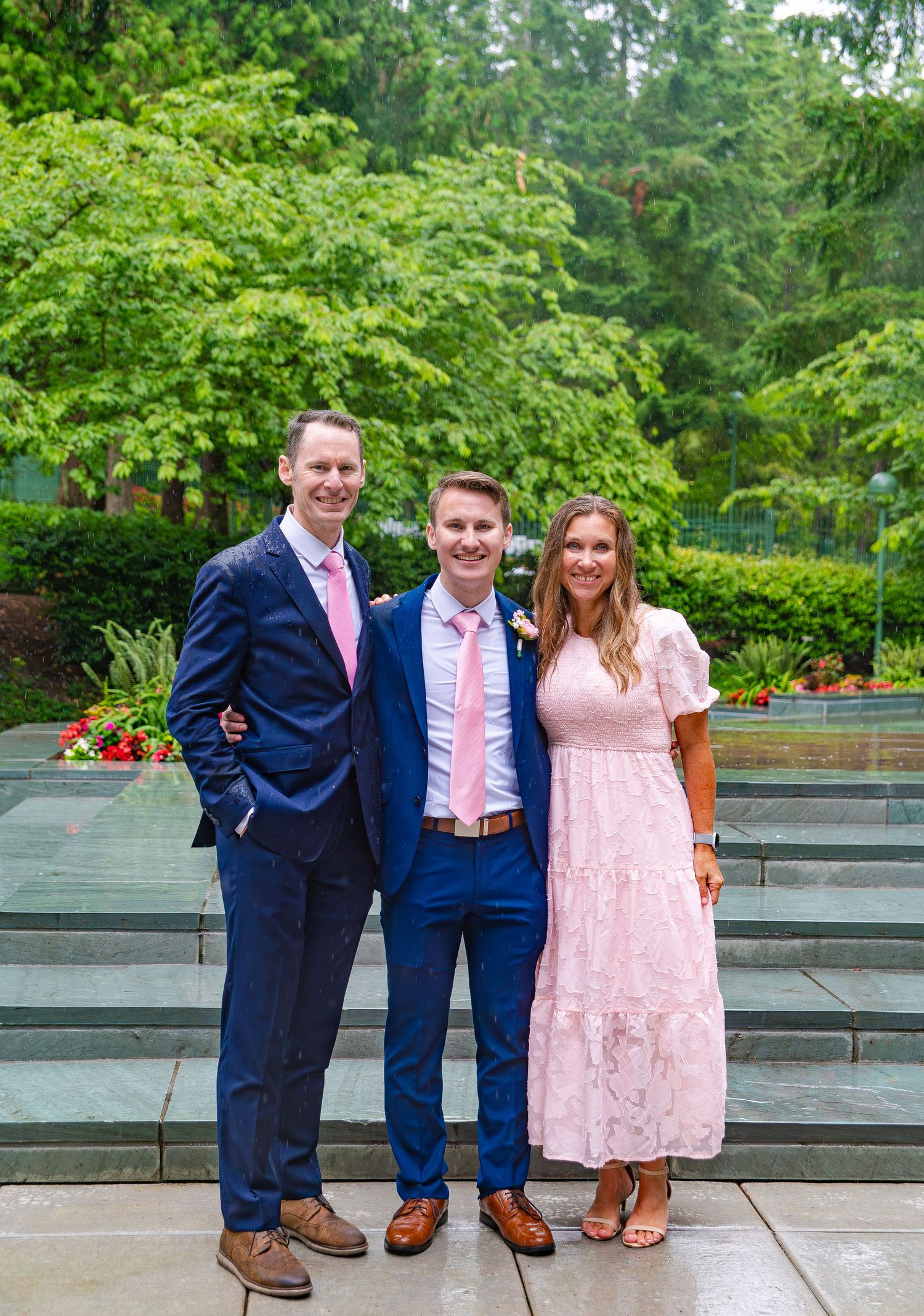 Wedding party group shots with coordinated outfits against landscaped garden setting.