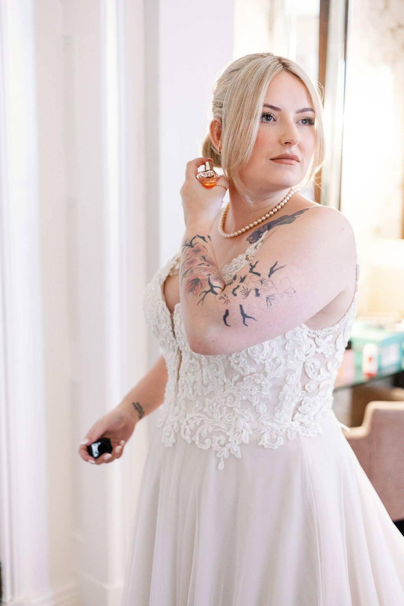 Beautiful wedding dress with delicate lace bodice and flowy tulle skirt showcased in natural window light.