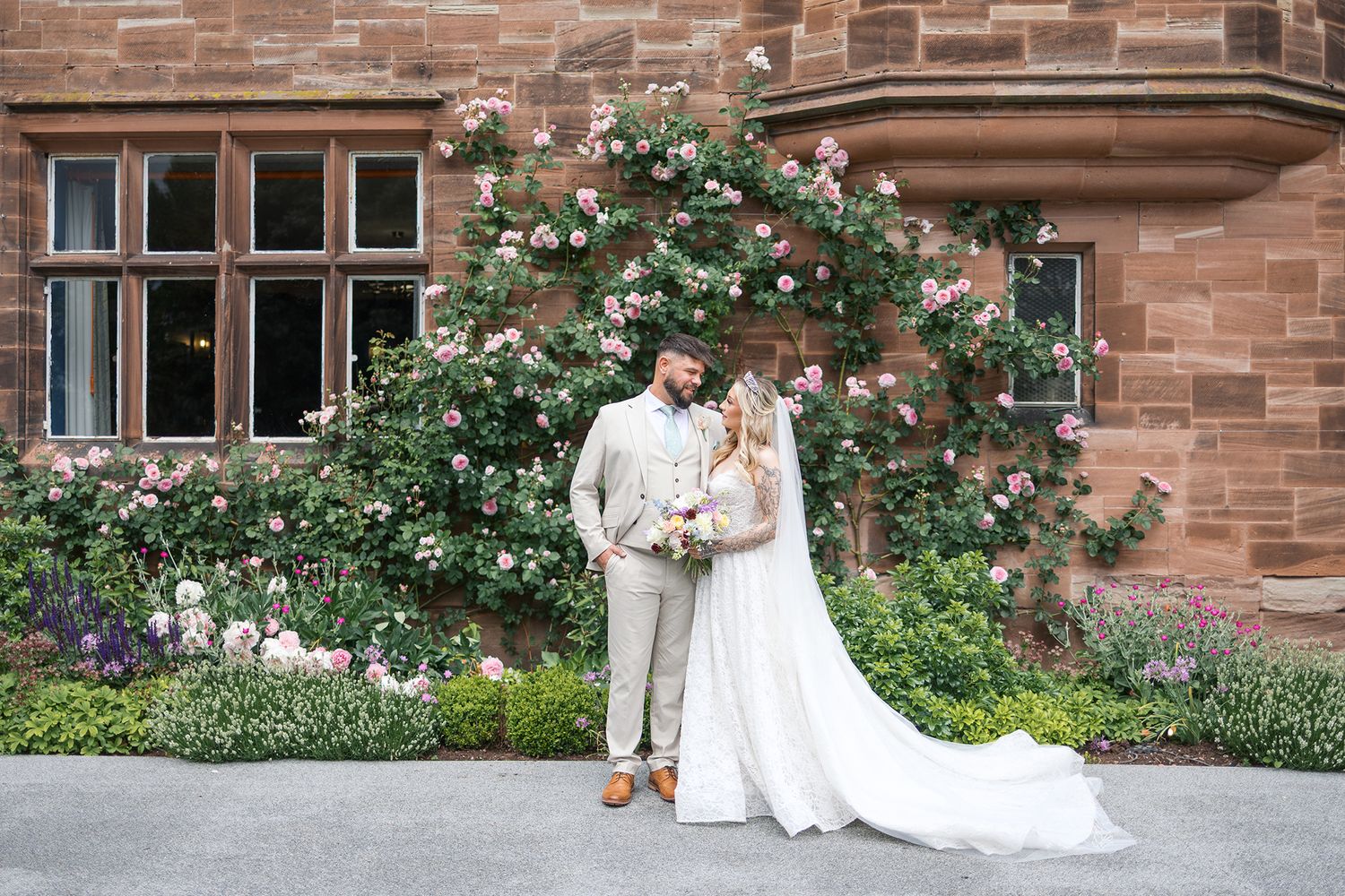 A split photo series showing the celebration of a wedding at a rustic brick building with white rose decor.