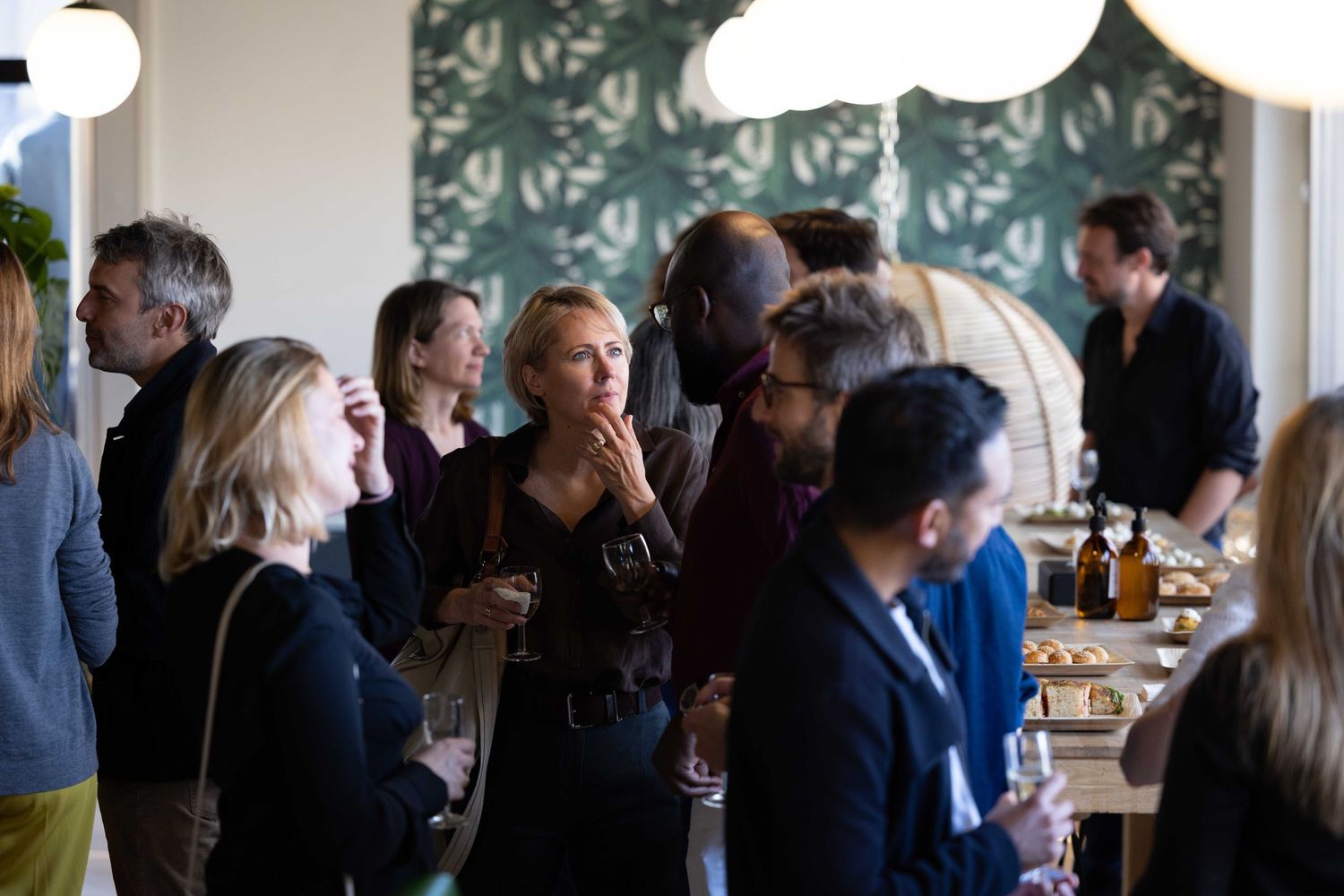 A crowd of people mingling and networking at an indoor business event.