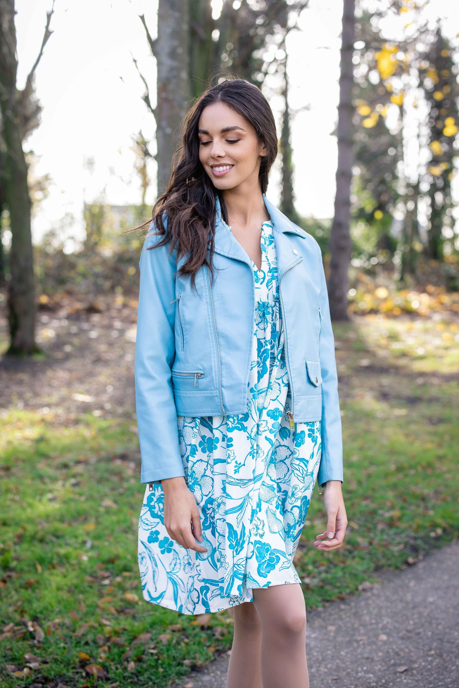 Photos de mode en veste en jean bleu et robe fleurie sur un chemin extérieur.