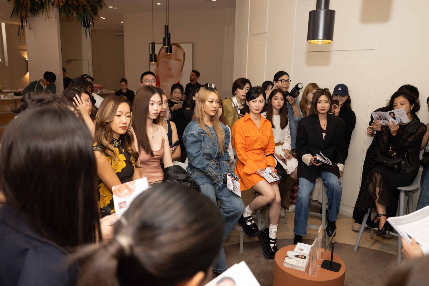 Crowded audience seated in rows at beauty industry event.