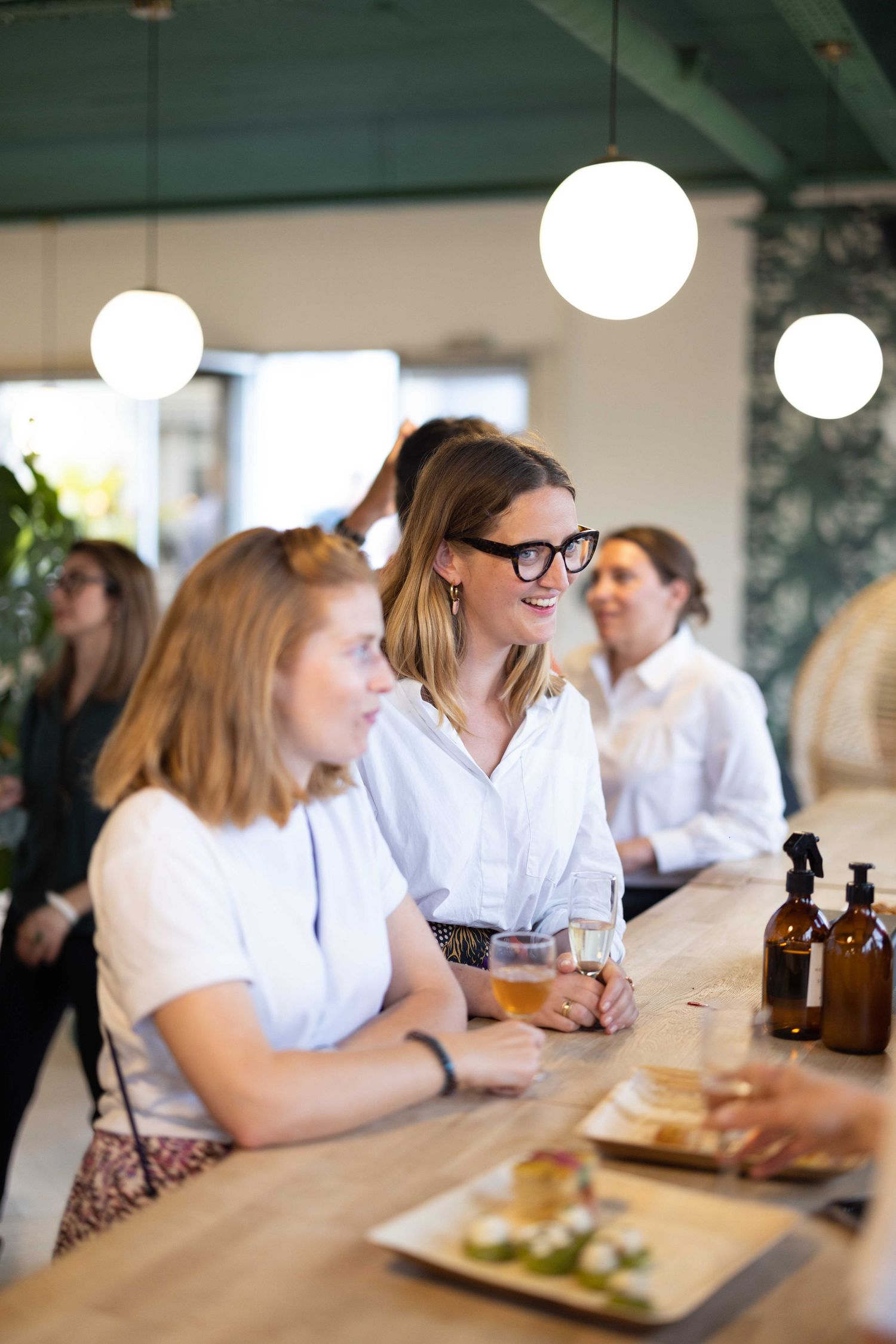 People enjoying drinks and food at a modern restaurant bar.
