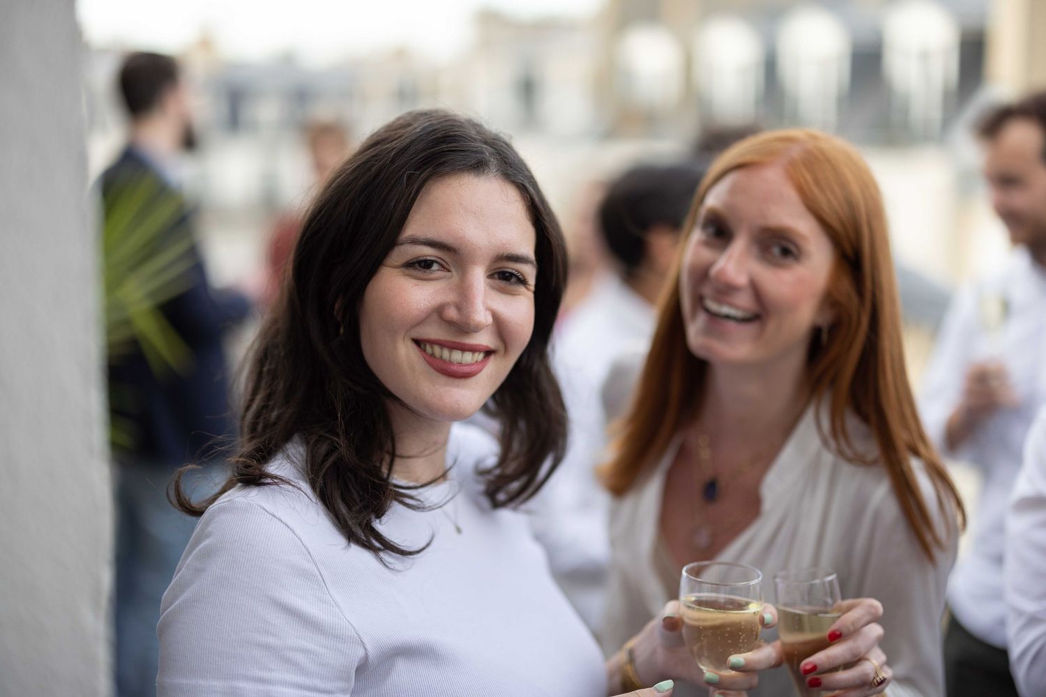 Two friends enjoying drinks and conversation at a social gathering.