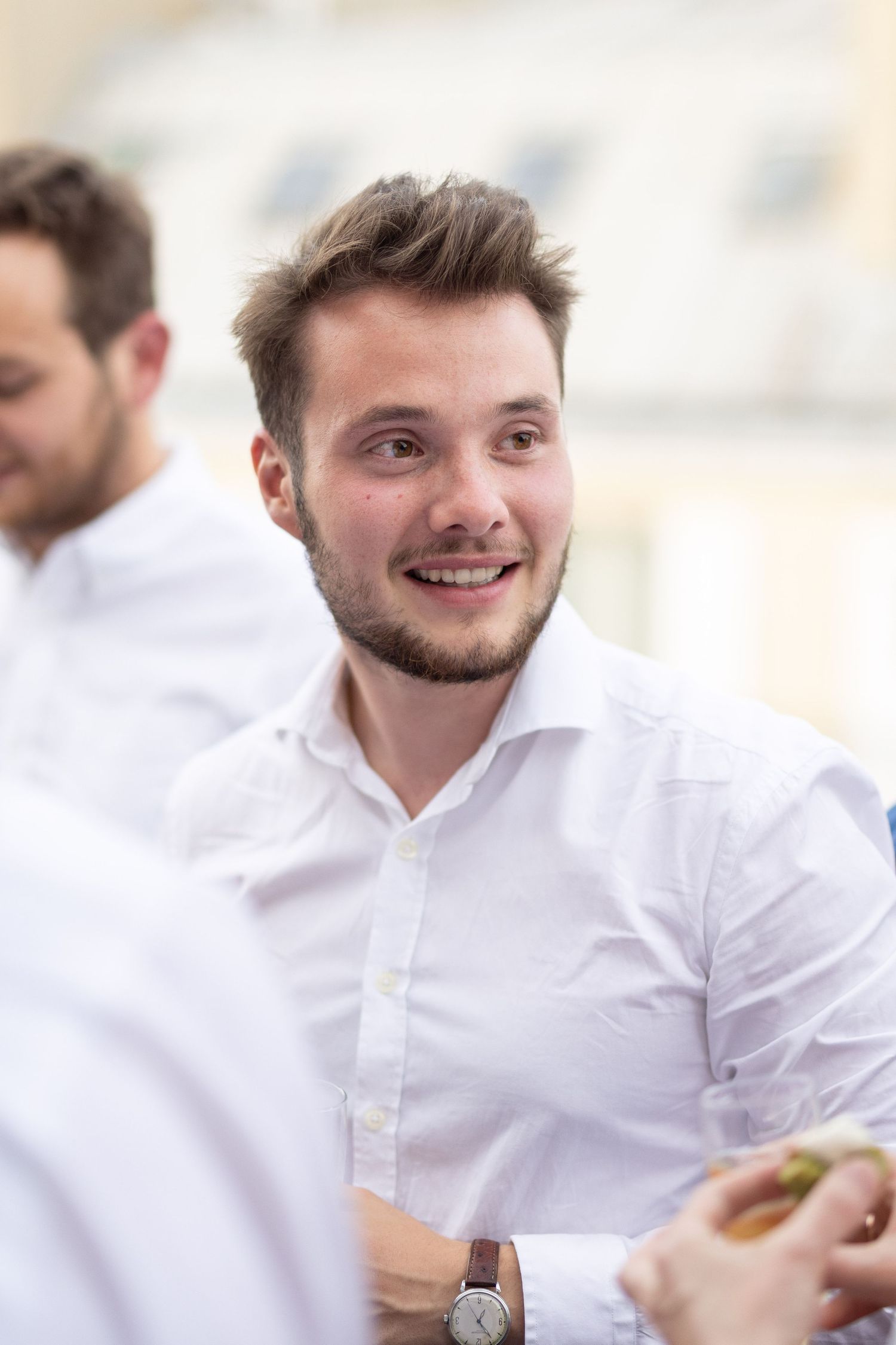 Person in white dress shirt smiling during a professional gathering.