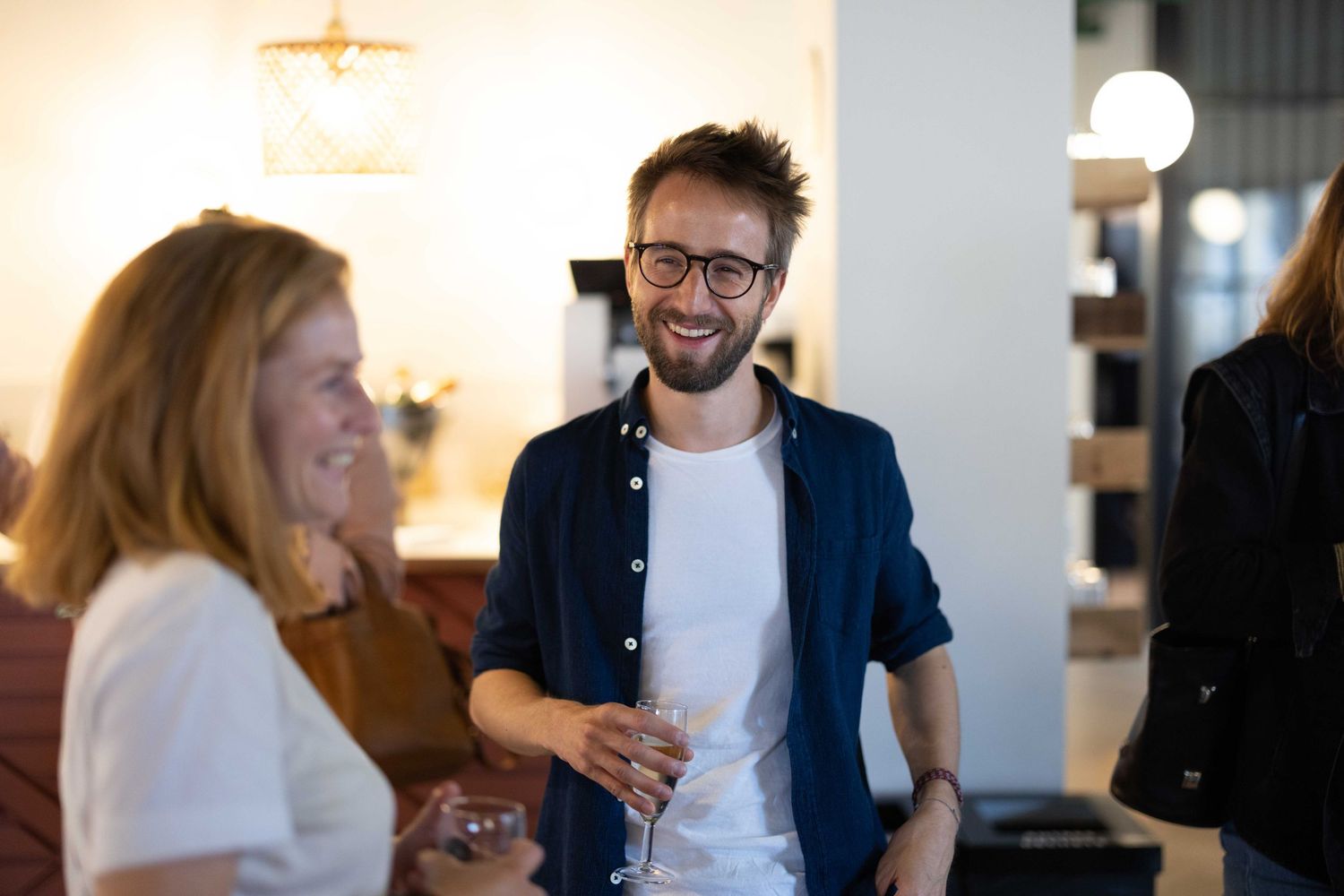 People mingling in a bright modern office space with casual business attire.
