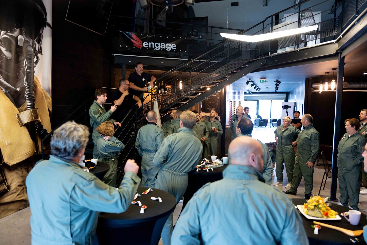 Group of people in matching uniforms socializing in an indoor space.
