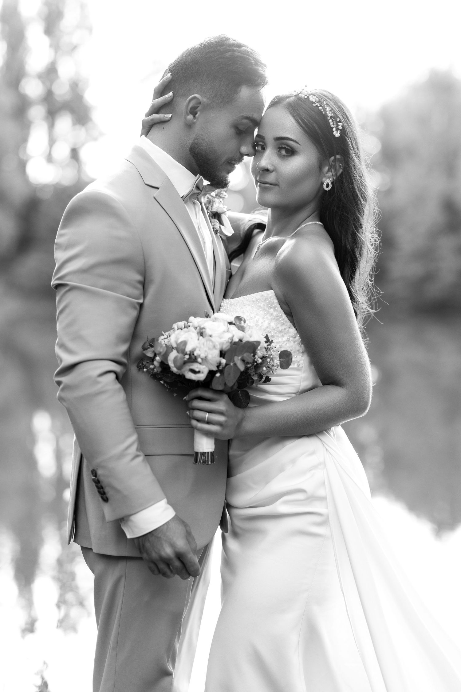 A romantic wedding couple embraces in multiple poses while holding a bouquet in an outdoor setting.