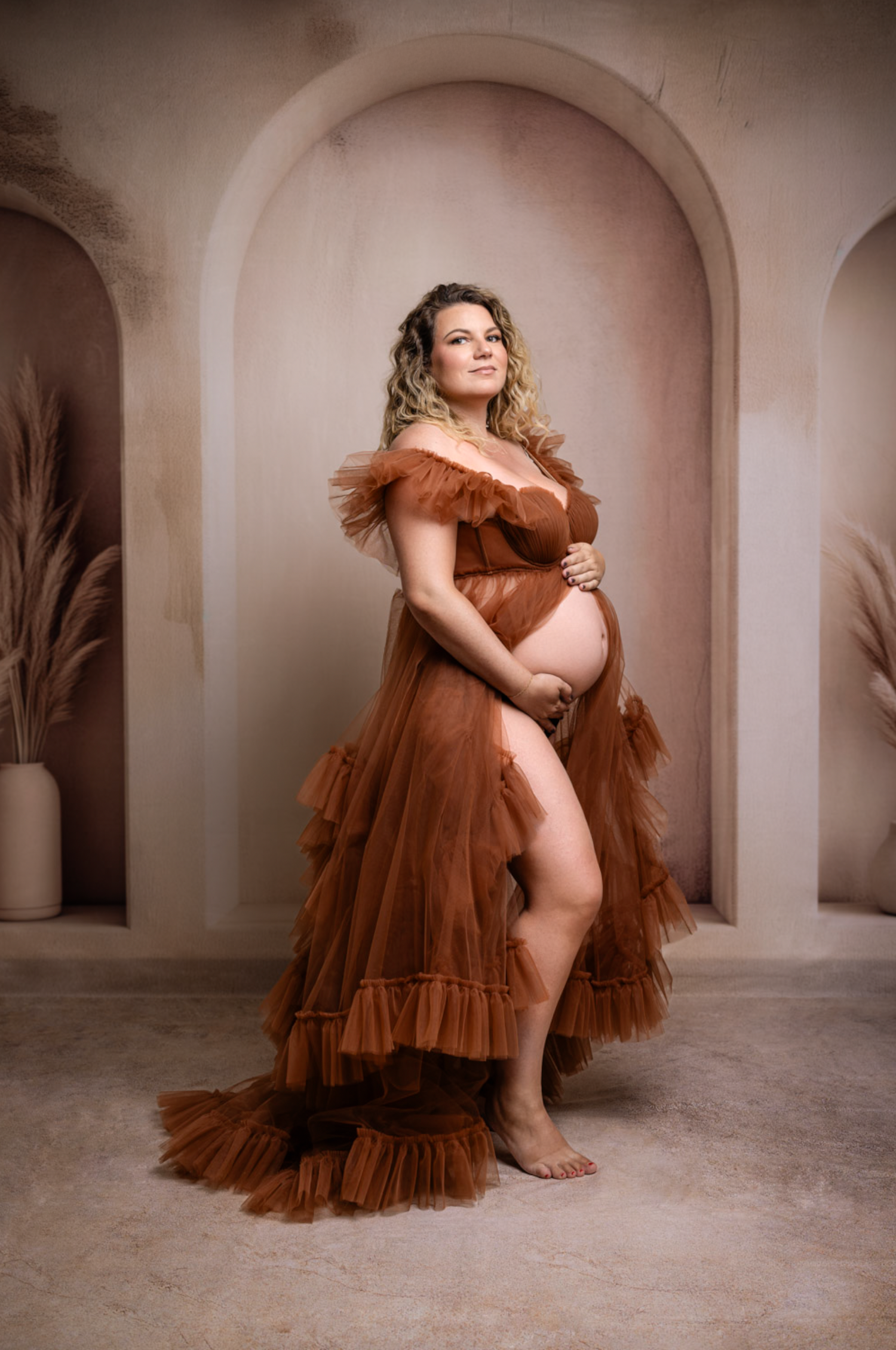 A brown tulle gown flows elegantly across a series of romantic arched interior photographs.
