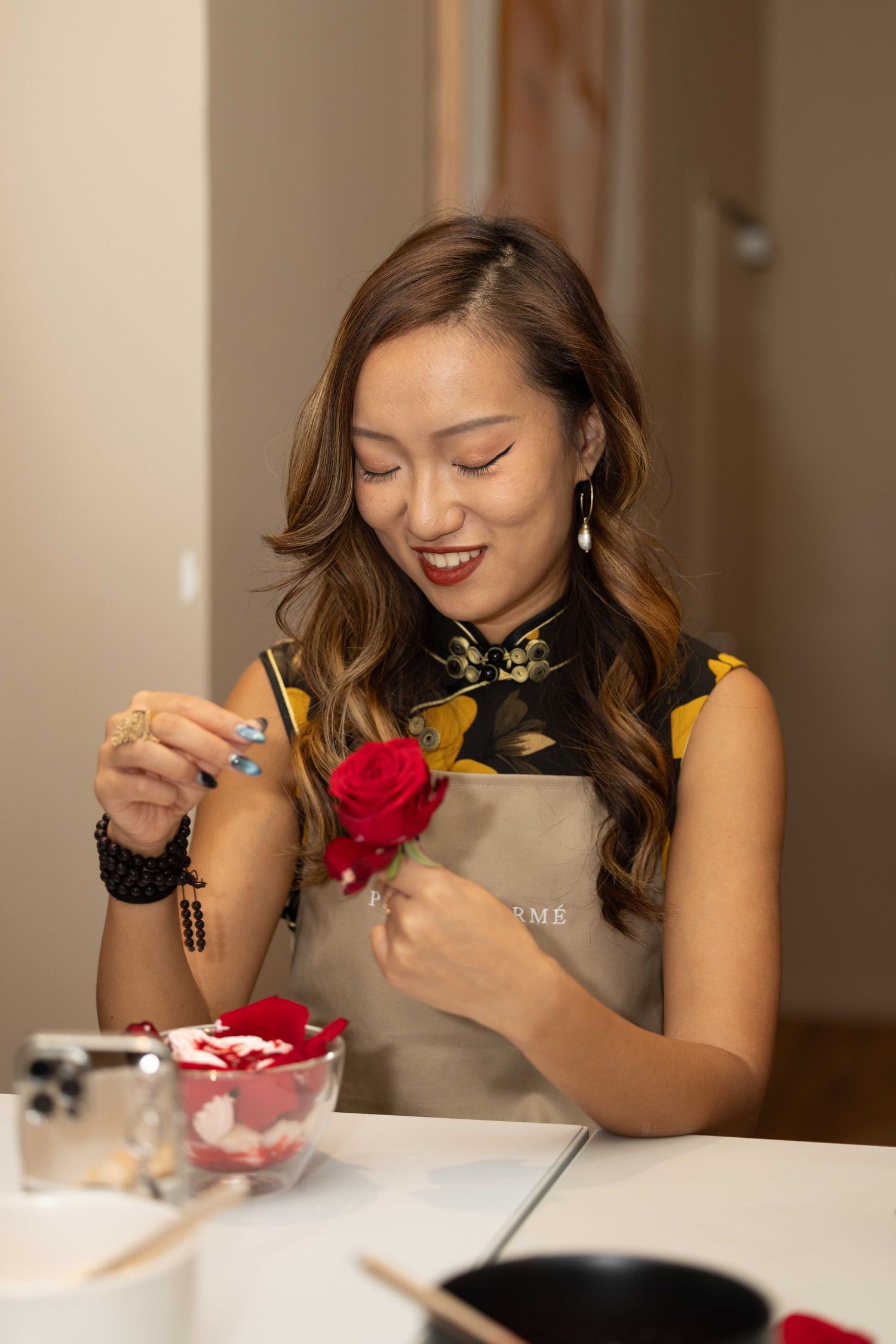 Person enjoying a dessert decorating activity with a red flower accent.