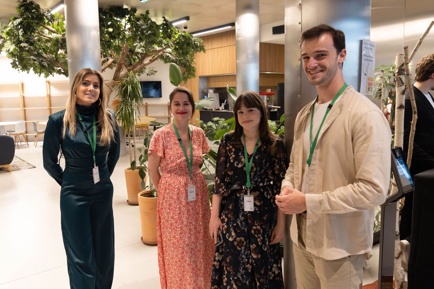 Professional networking event in a bright office space with greenery and modern decor.