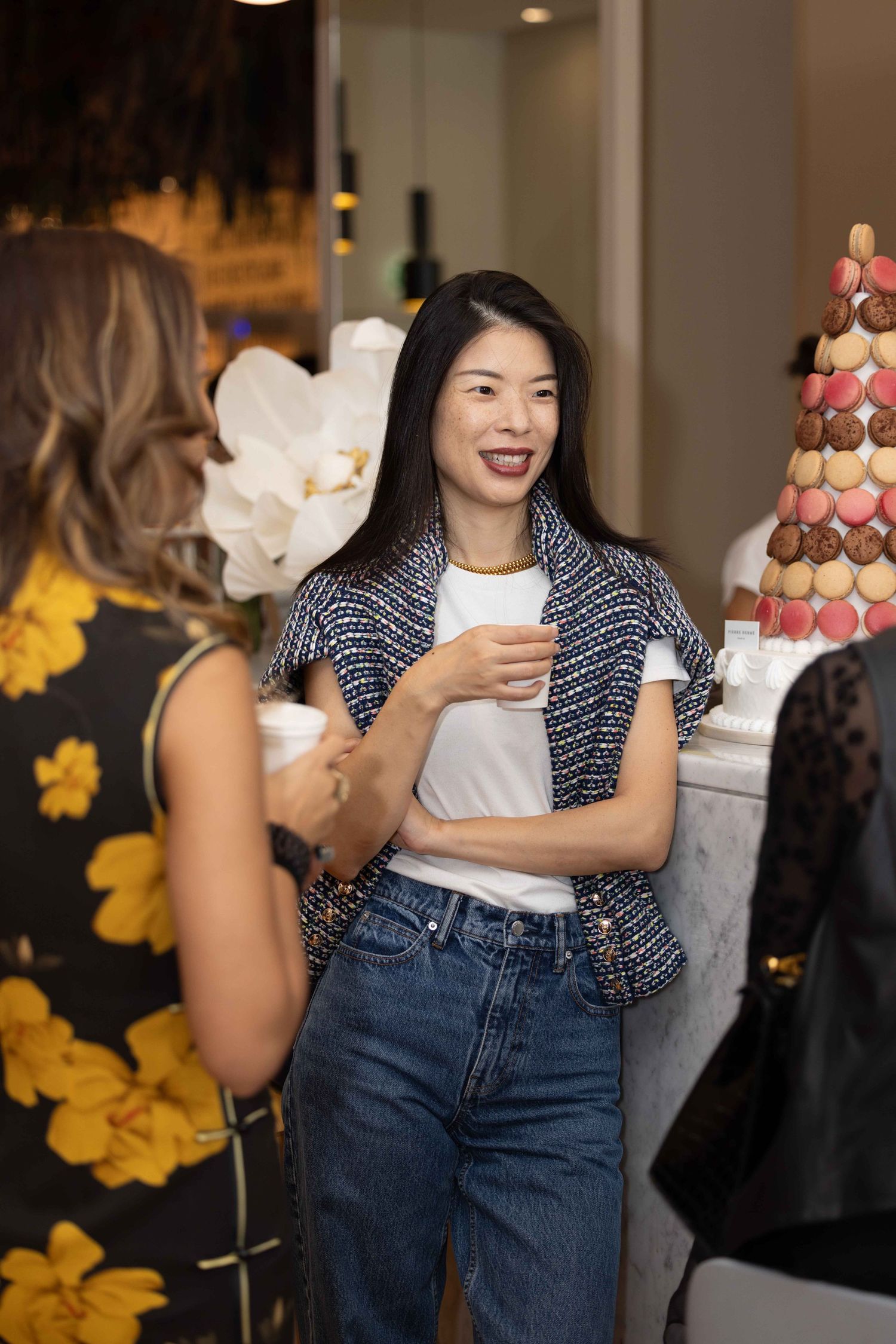 Casual gathering with attendees wearing denim and polka dot patterns enjoying refreshments.