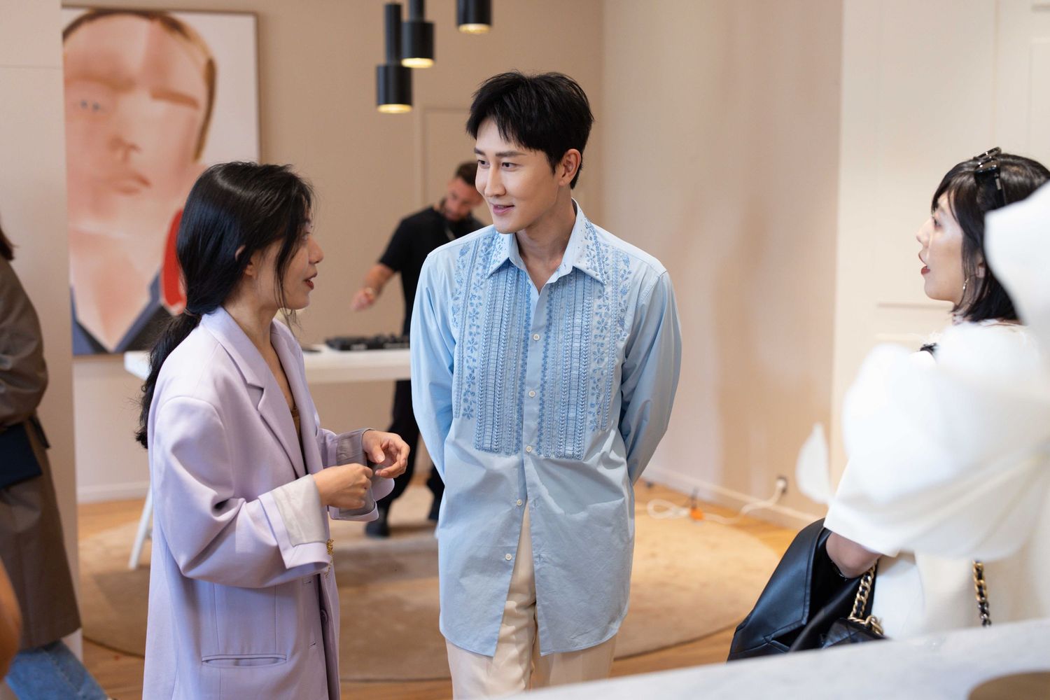 People chatting in a modern indoor space with minimalist decor and natural lighting.