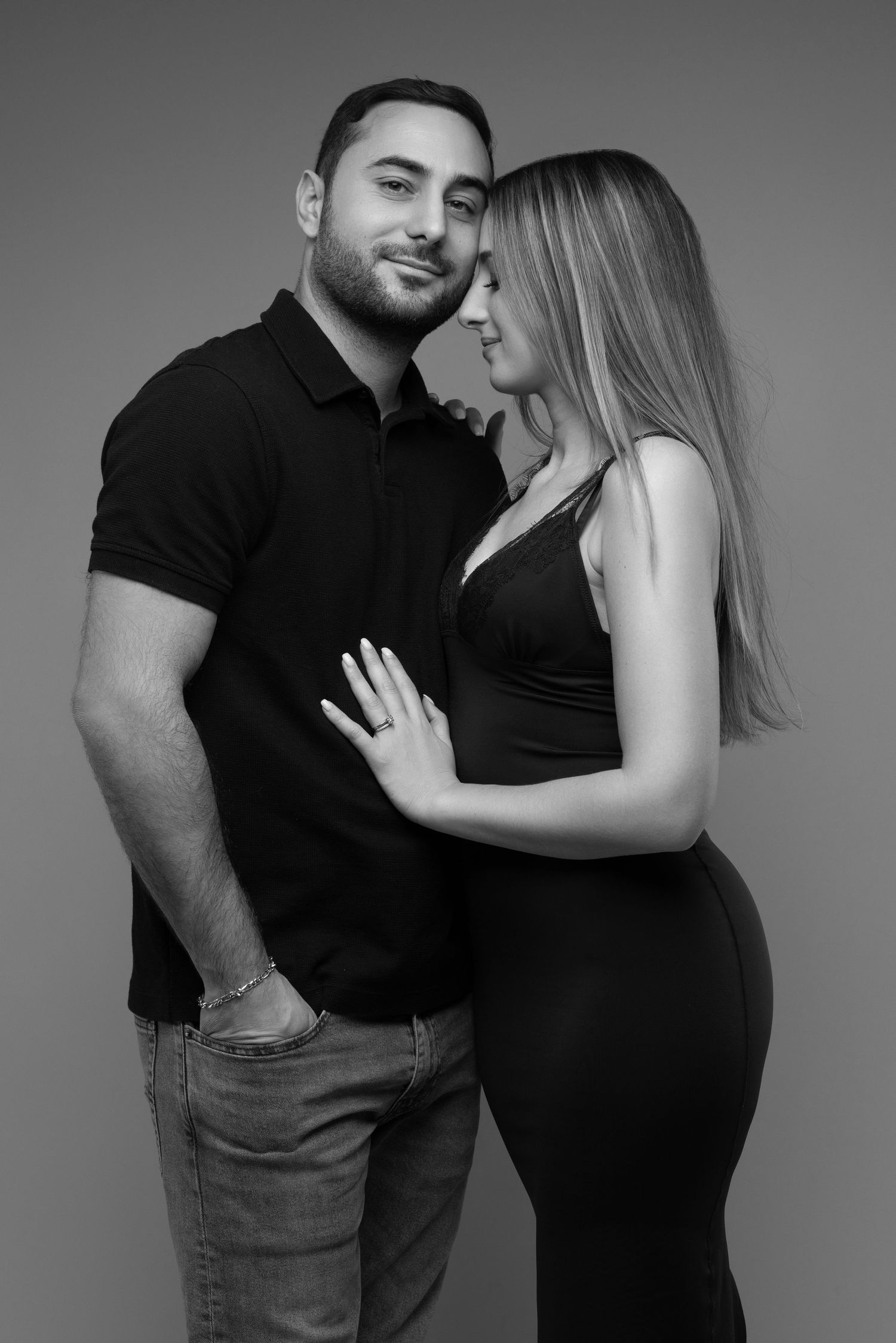 A couple in black clothing poses intimately in a series of black and white romantic portraits.