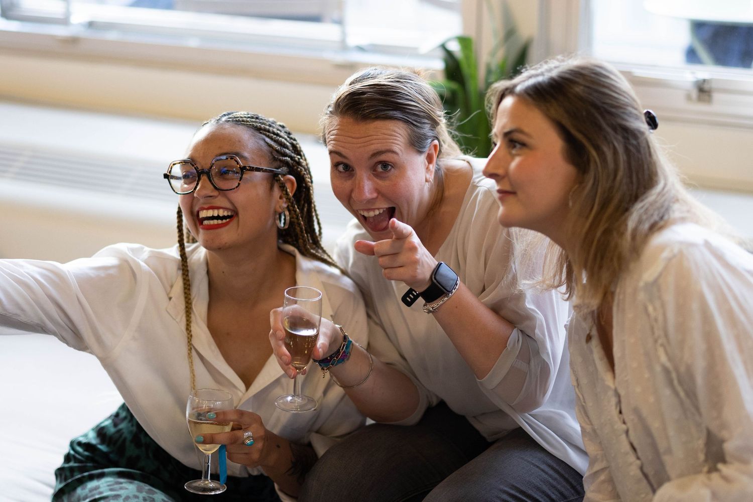 Group of people in white shirts laughing together at a casual gathering.