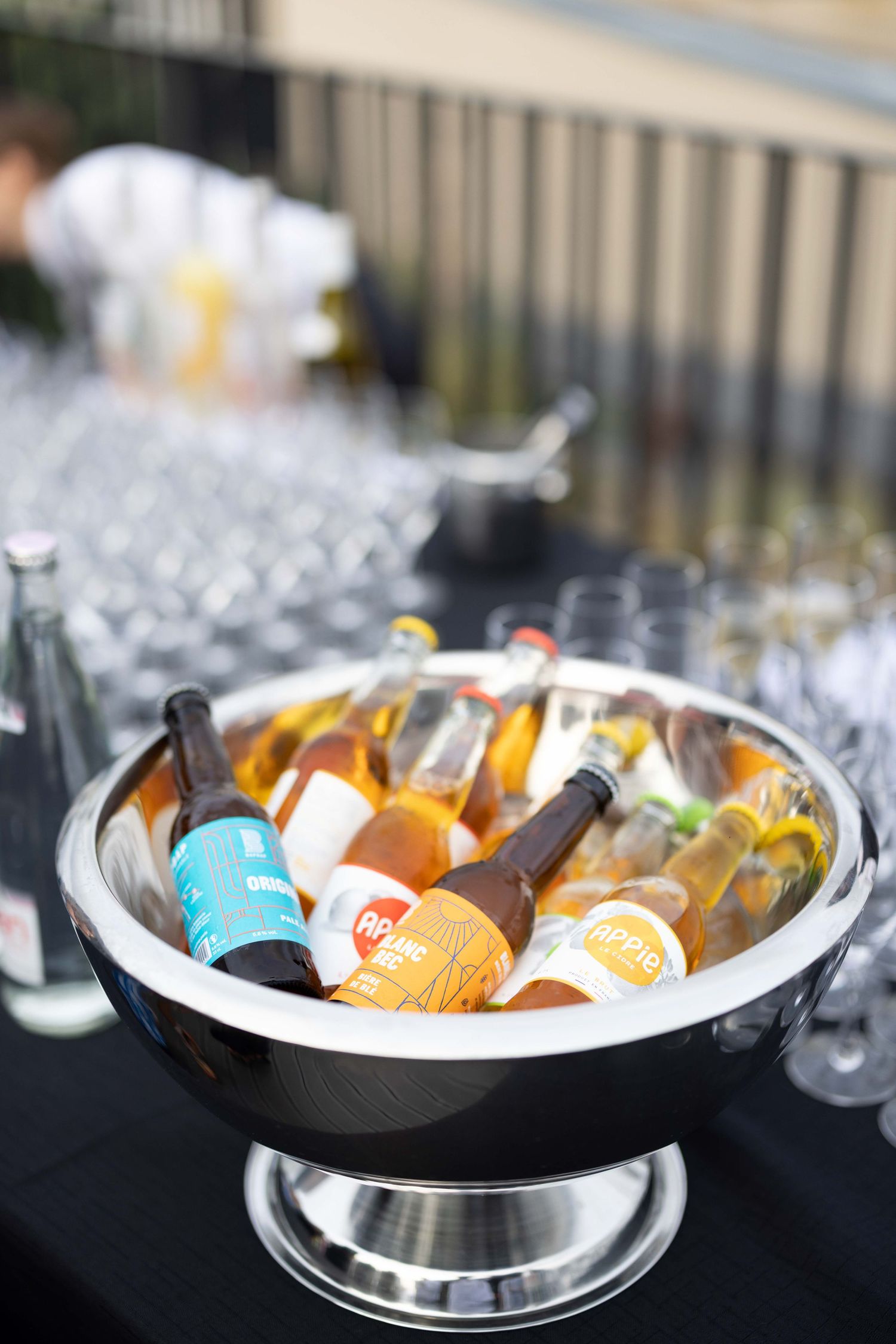 Chilled beverages in ice buckets displayed on dark tablecloth at catered event.