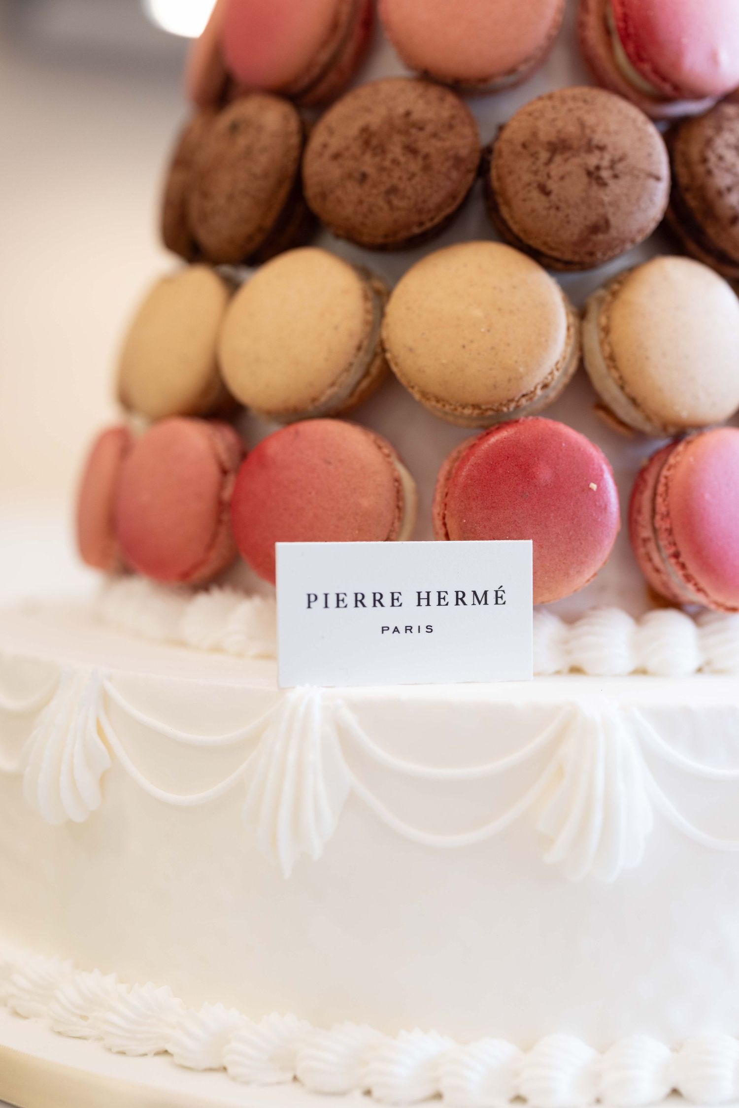 Colorful Pierre Hermé macarons arranged in elegant display.
