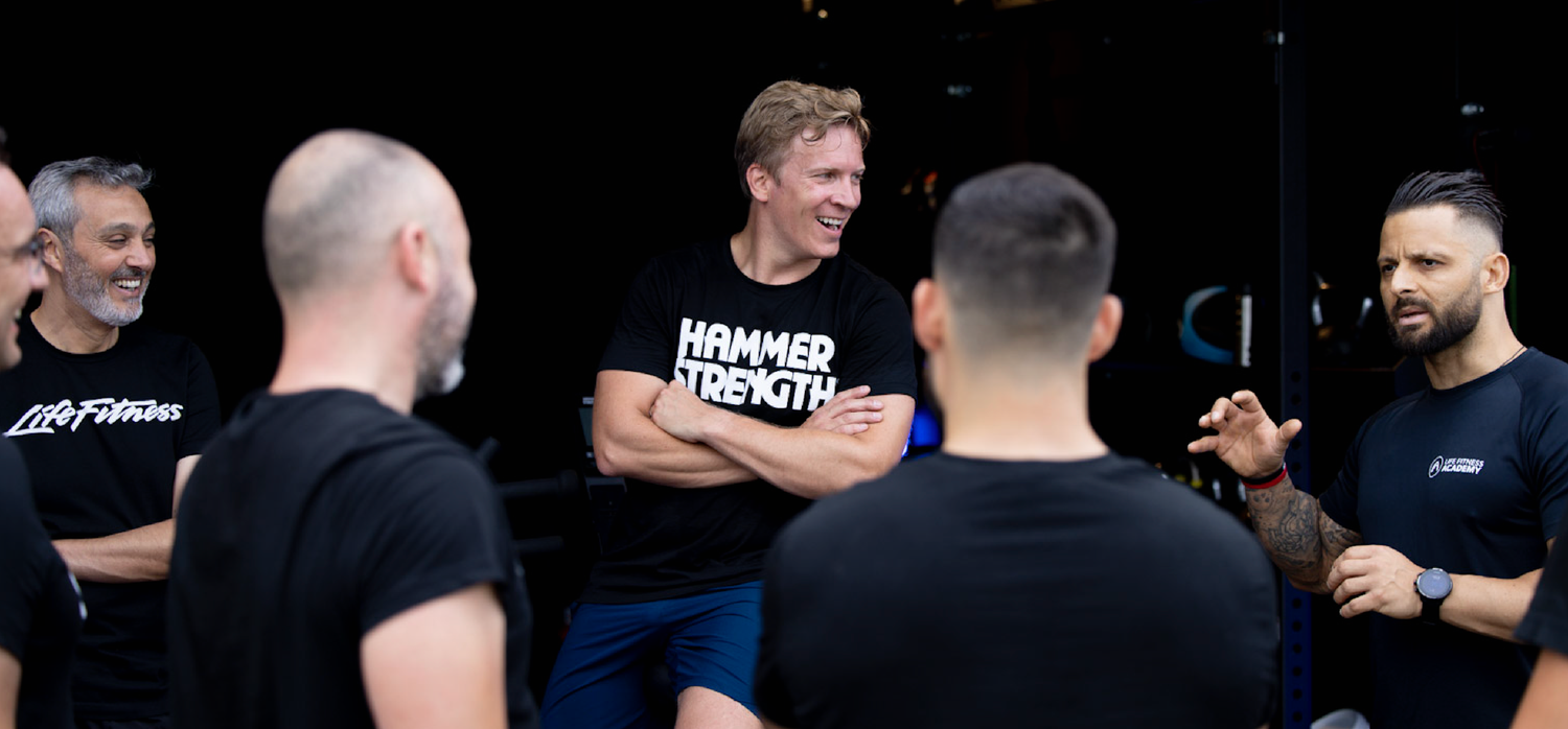 A group of people in black attire gathered in what appears to be a social or networking event setting.