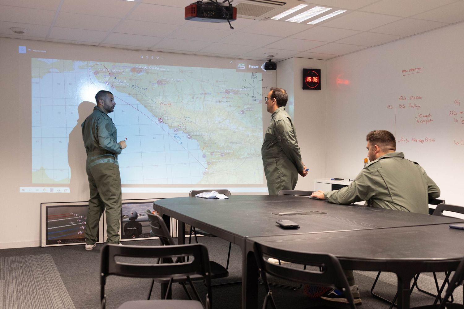 Conference room with projector screen showing maps and presentations.