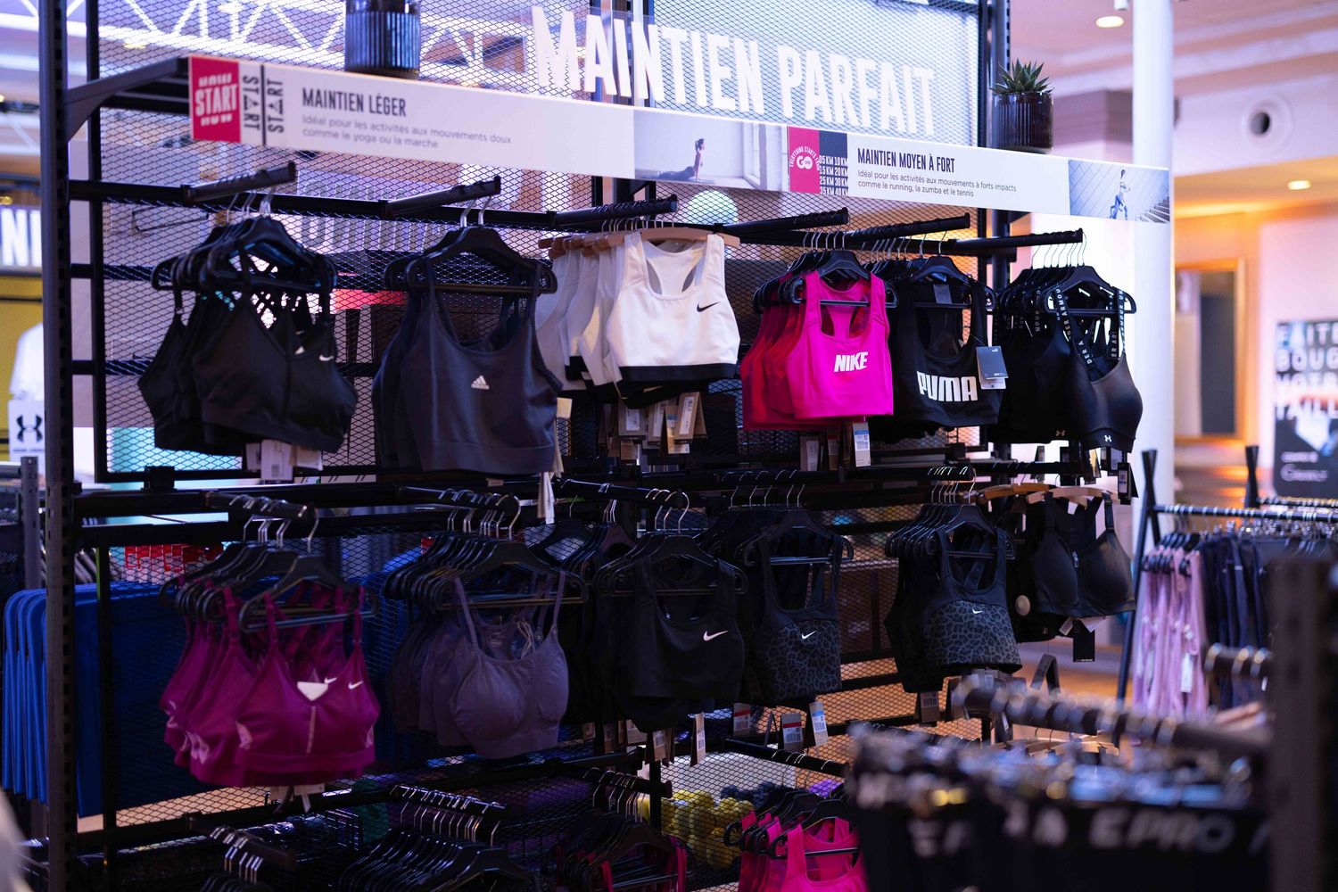 Modern retail space with clothing racks and merchandise displays under ambient lighting.