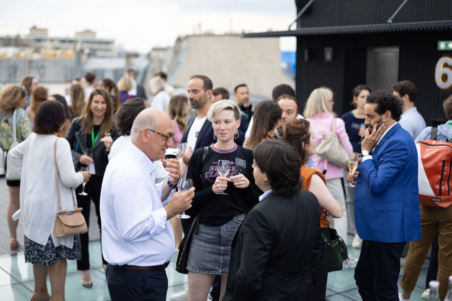 Diverse crowd mingling at a rooftop business networking event.