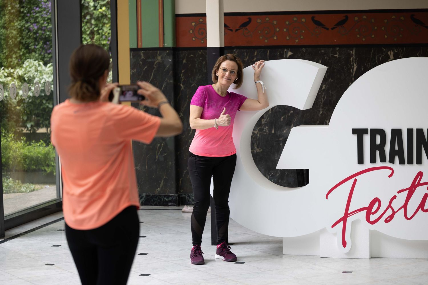 People photographing promotional materials and signage at a fitness event.