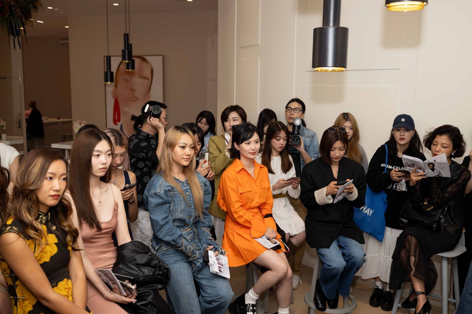 Audience members watching intently during beauty industry presentation.